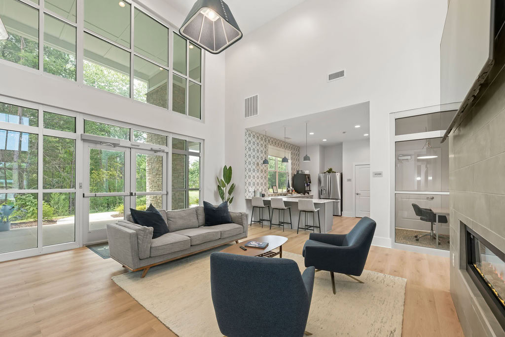 A lounge, featuring a private work space, and a kitchen area at the Courtney Ridge apartments in Charlotte, NC