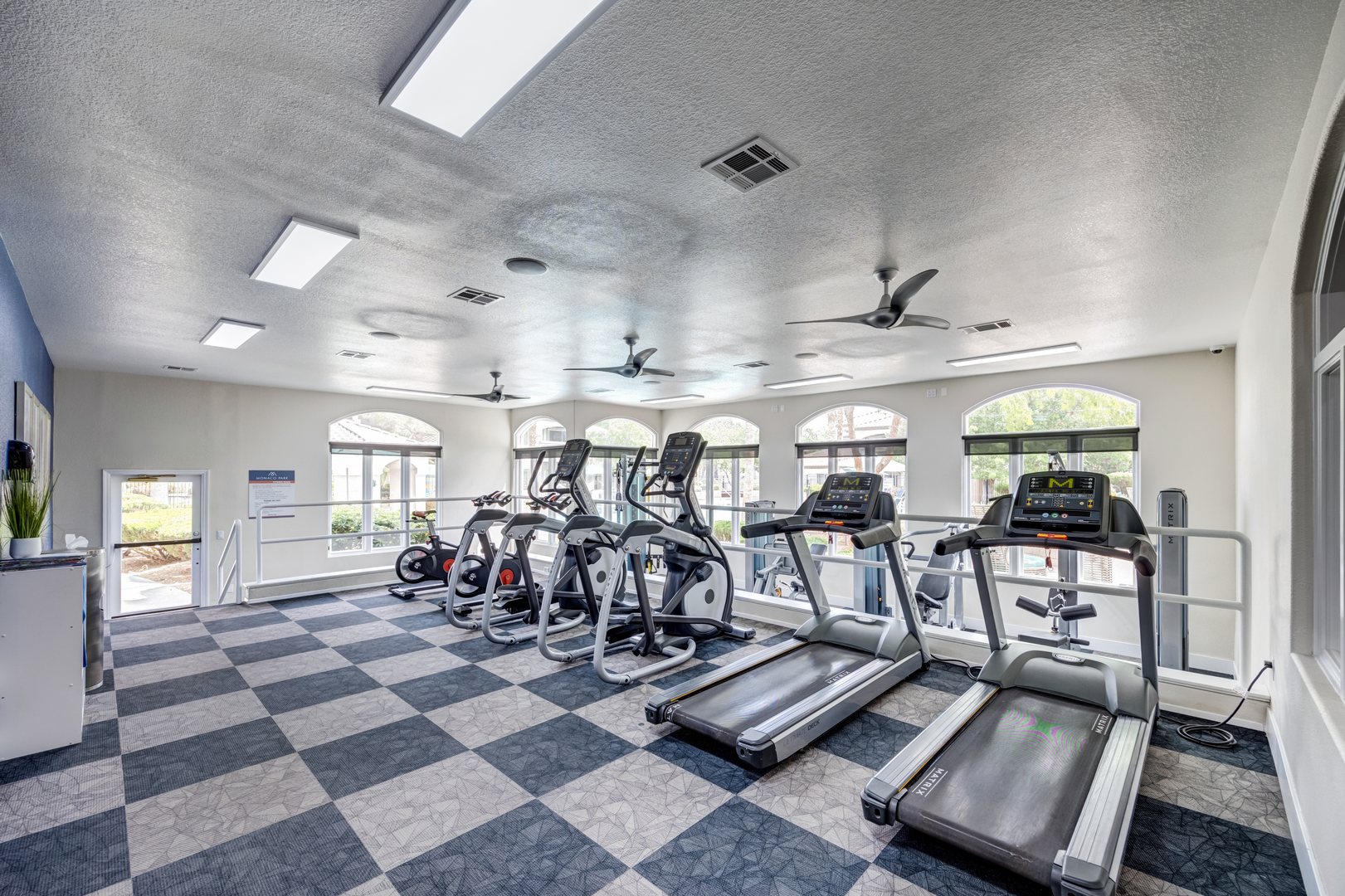 A fitness Center with treadmills, elipticals and stationary bikes in a room at The Monaco Park apartments near red rock las vegas