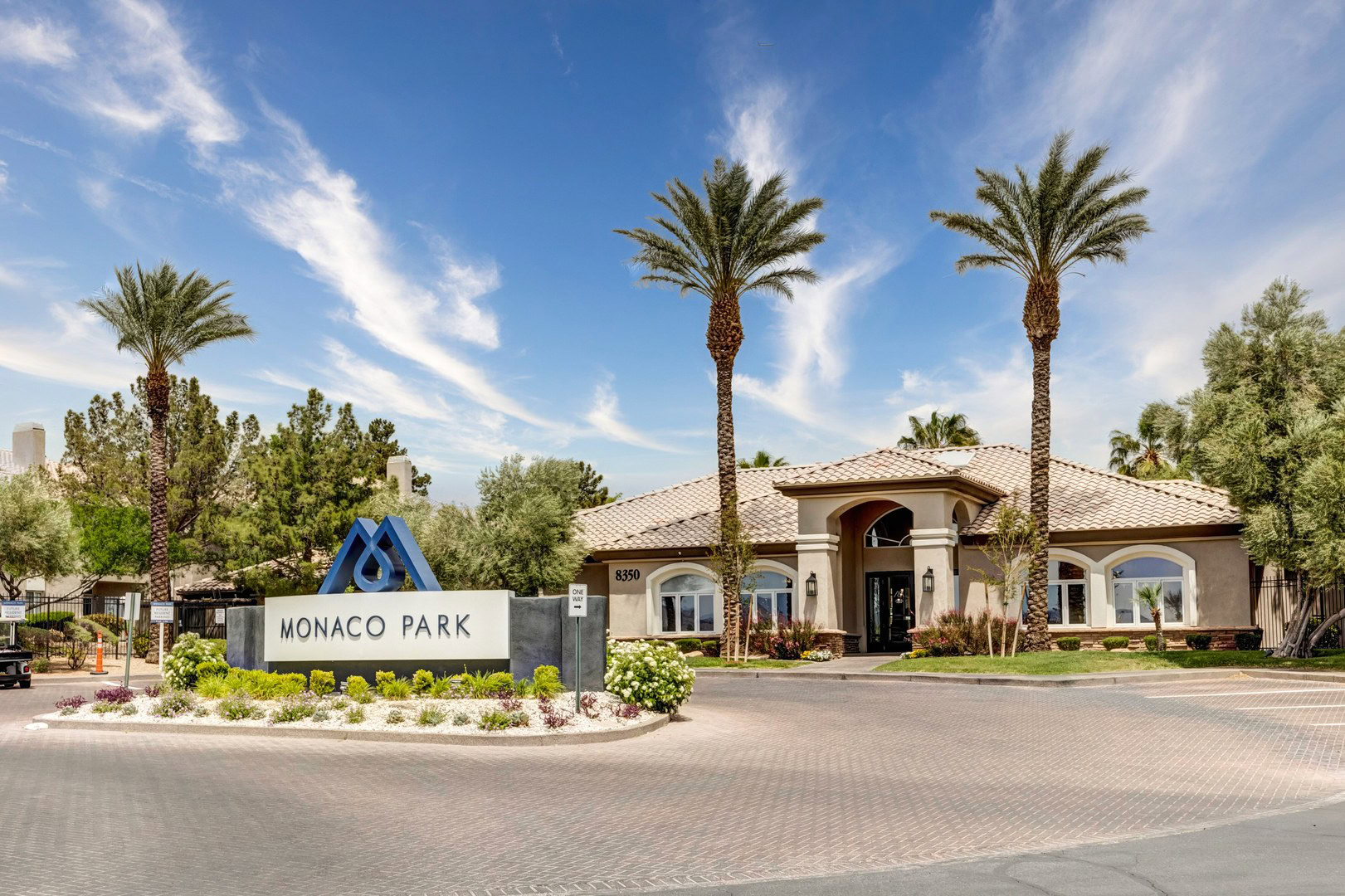 A Monaco Park sign at a roundabout in front of an amenity building in Spring Valley apartments in Las Vegas