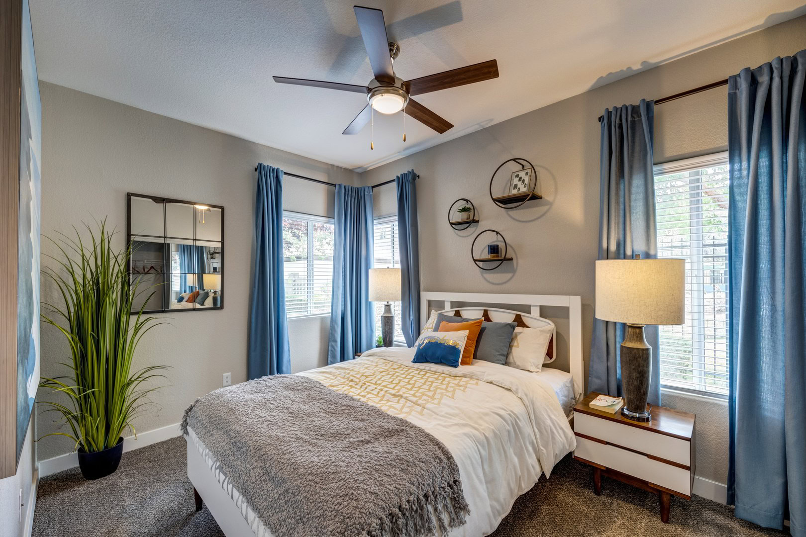 A bedroom with carpet flooring and two large windows at the Spring Valley apartments for rent, Monaco Park