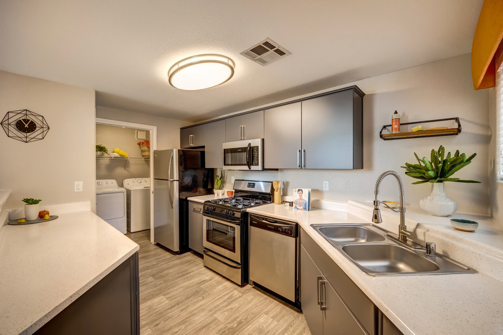 A kitchen with stainless steel appliances featuring a laundry nook at the Spring Valley Monaco Park apartments in Las Vegas