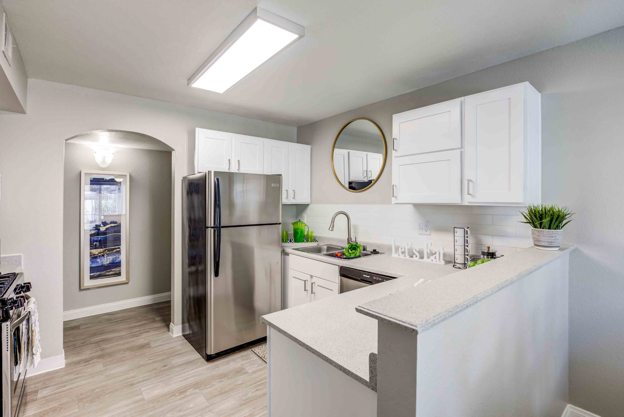 A kitchen with a peninsula, and an archway to a hallway at the Vintage luxury apartments in Pleasanton, CA
