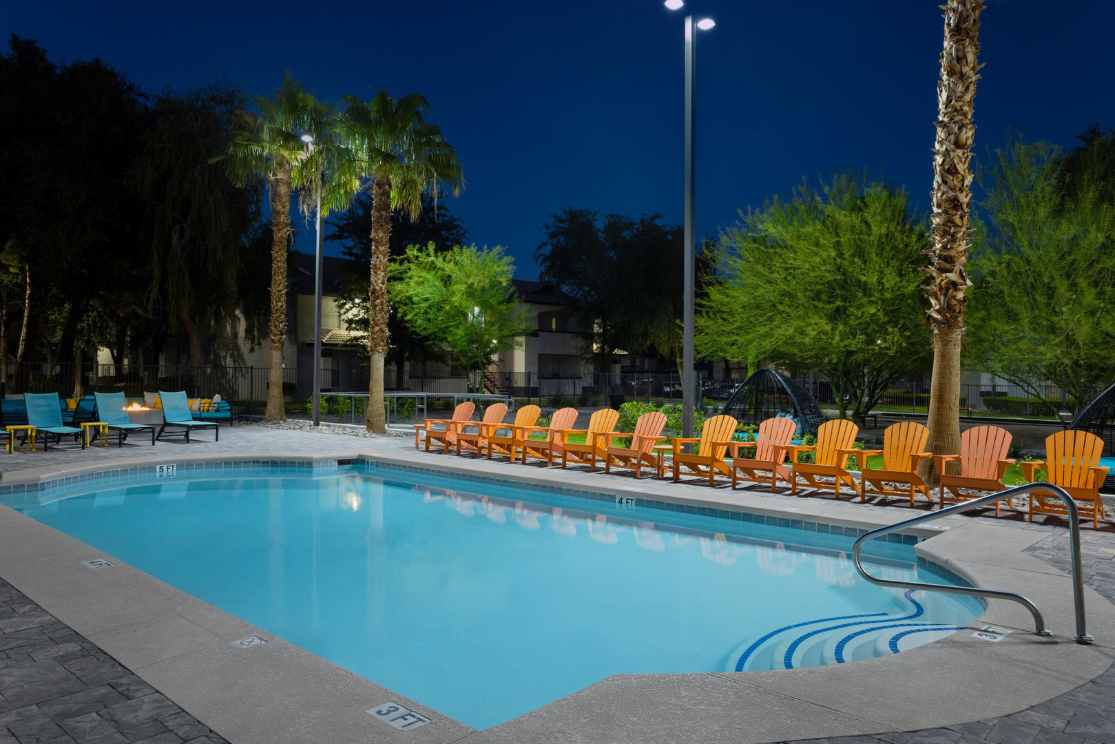 A pool with outdoor lounging chairs at the Xander 3900 apartments in Centenial Hills