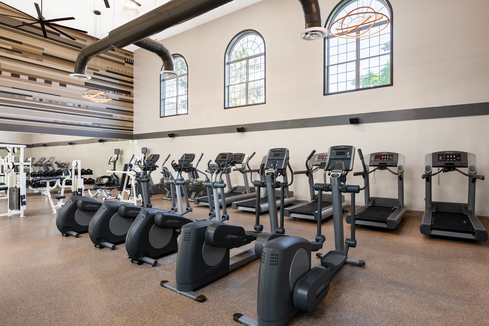 Fitness center with abundant light and treadmills.