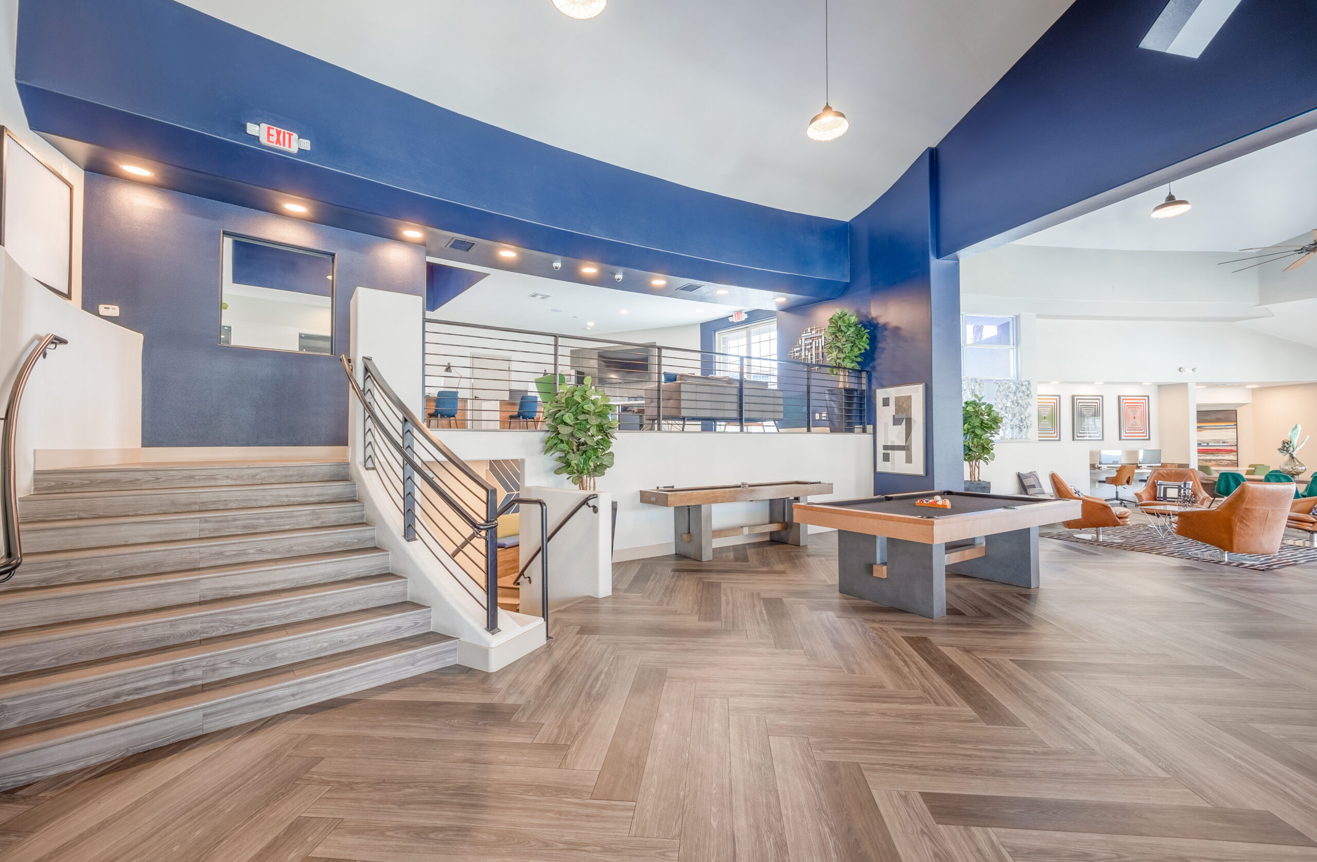 Curved stairs to the bottom level lobby lounge featuring a pool table, shuffle board and work area's at The Met Las Vegas apartments for rent