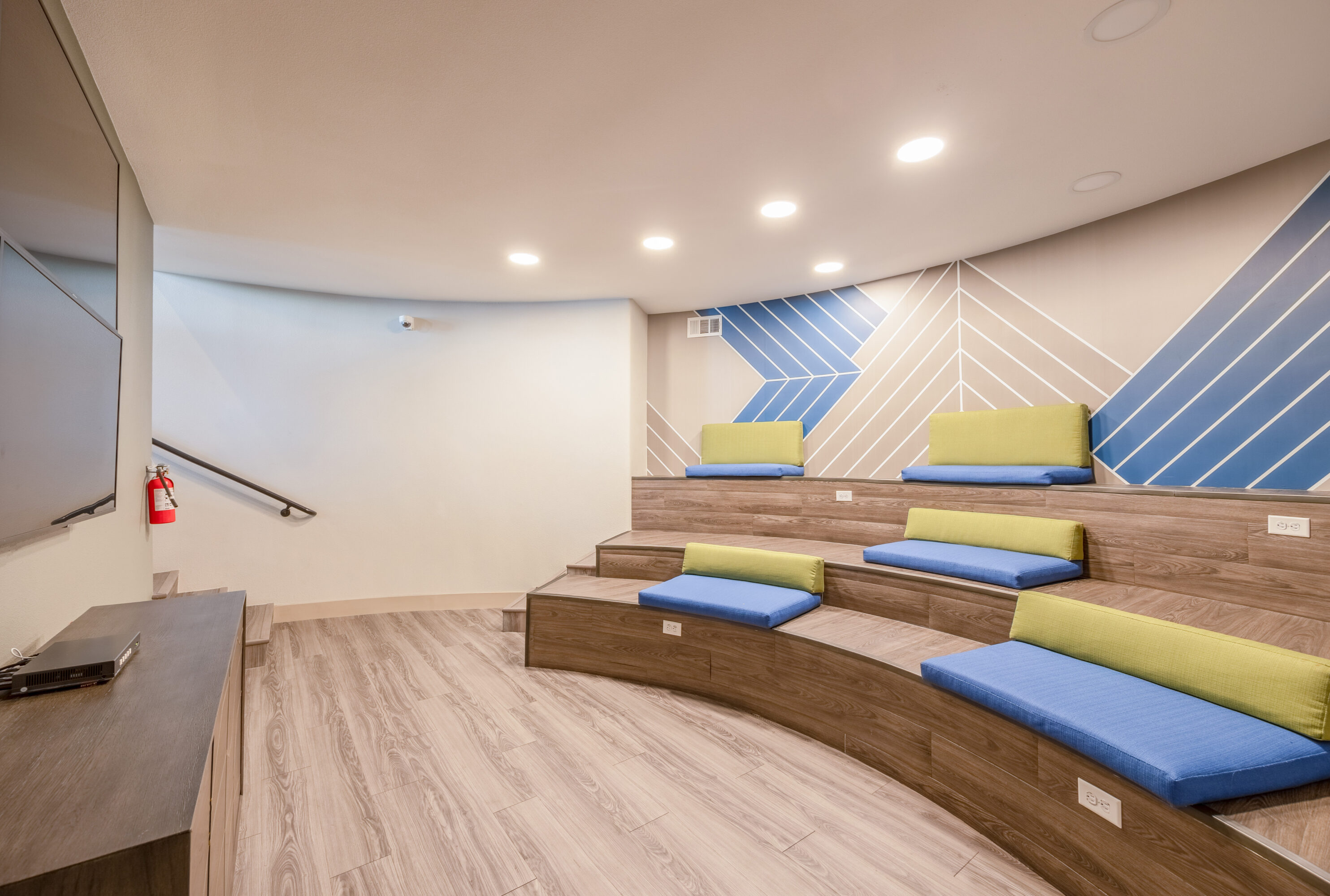 A movie theatre with ampitheatre stair seating with cushions at The Met Las Vegas apartments in Northwest Las Vegas