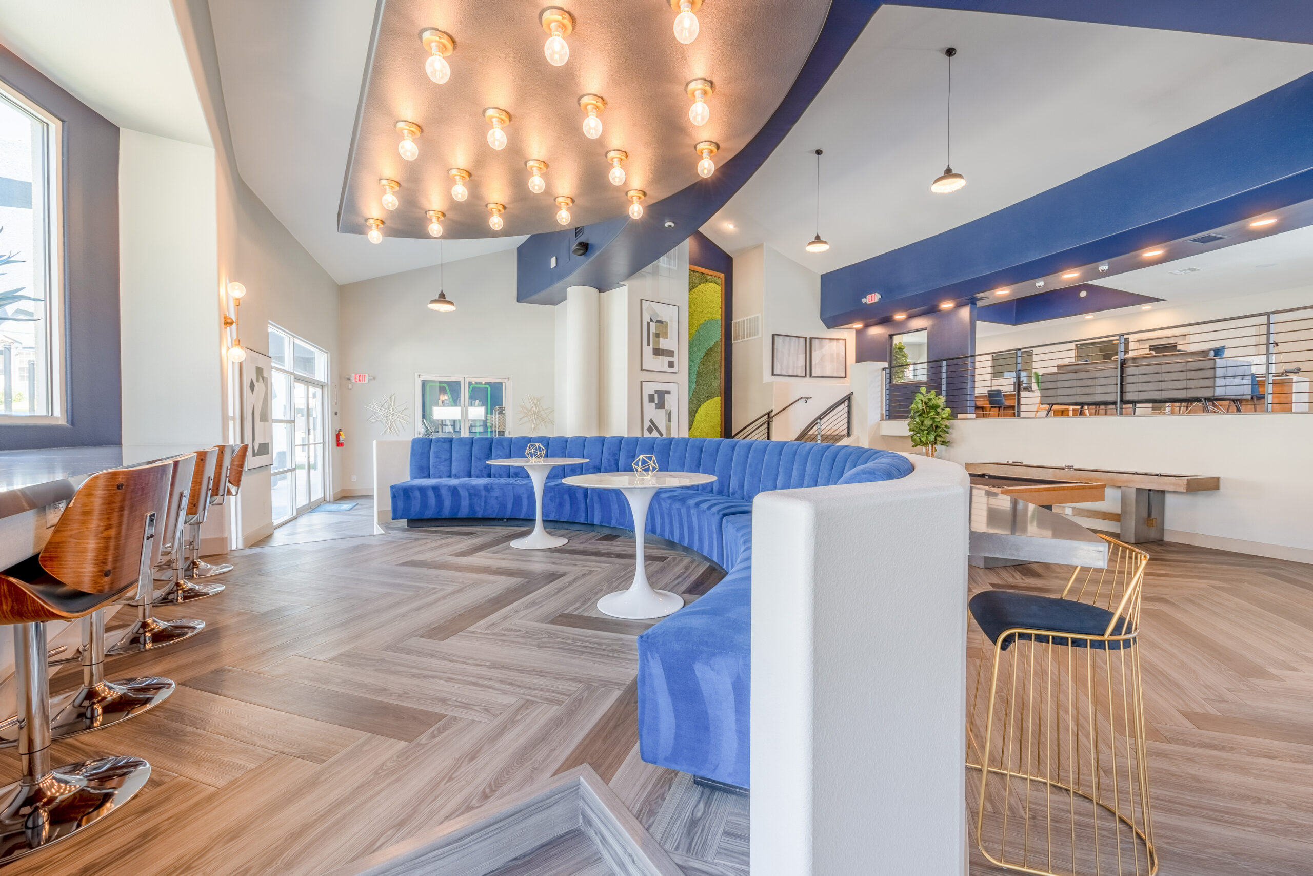 The bottom level of the lobby lounge with blue booth seating, and high chairs and counters at The Met Las Vegas apartments for rent