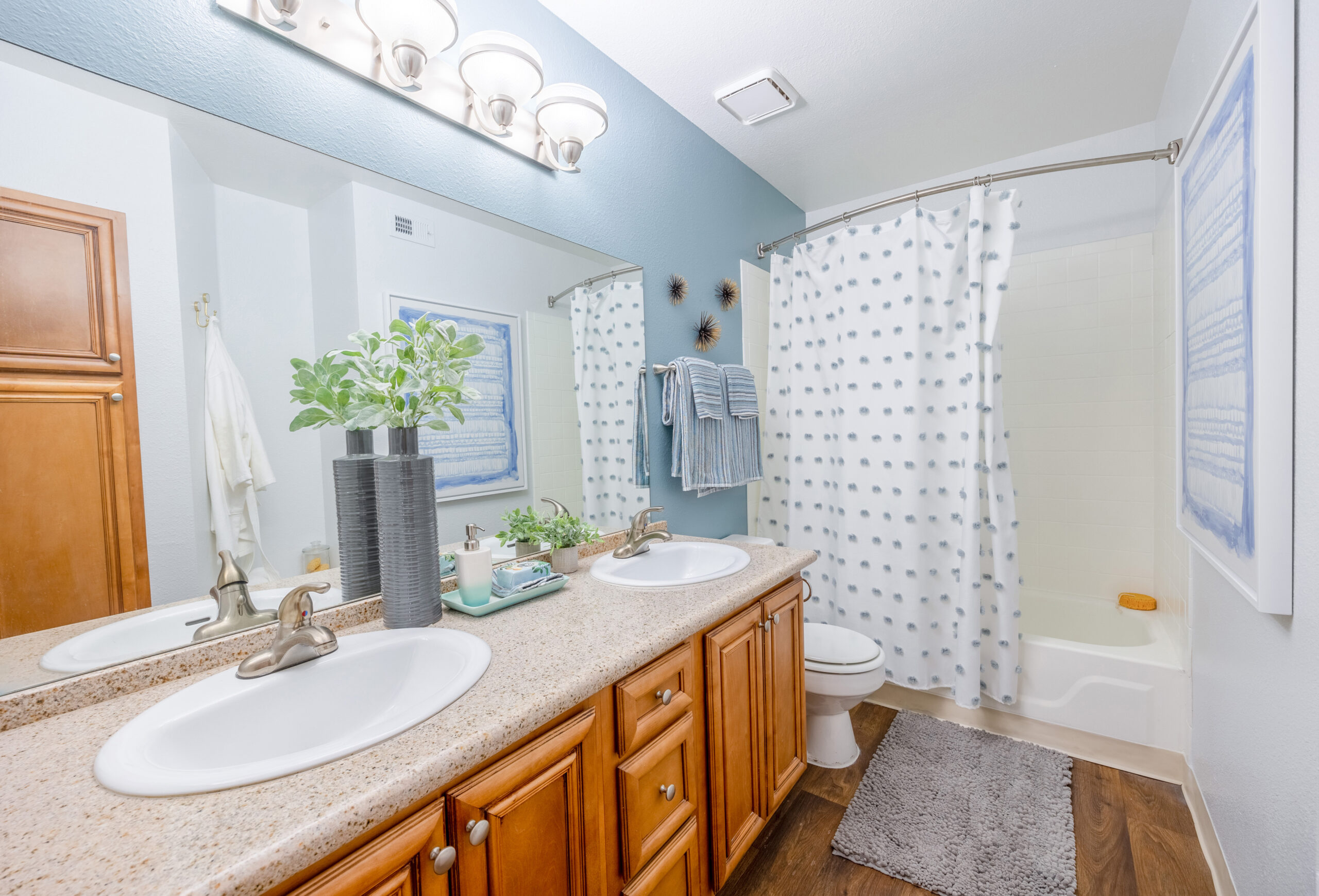 A bathroom featuring a his and hers vanity and a tub with a shower head at The Met Las Vegas apartments in Las Vegas