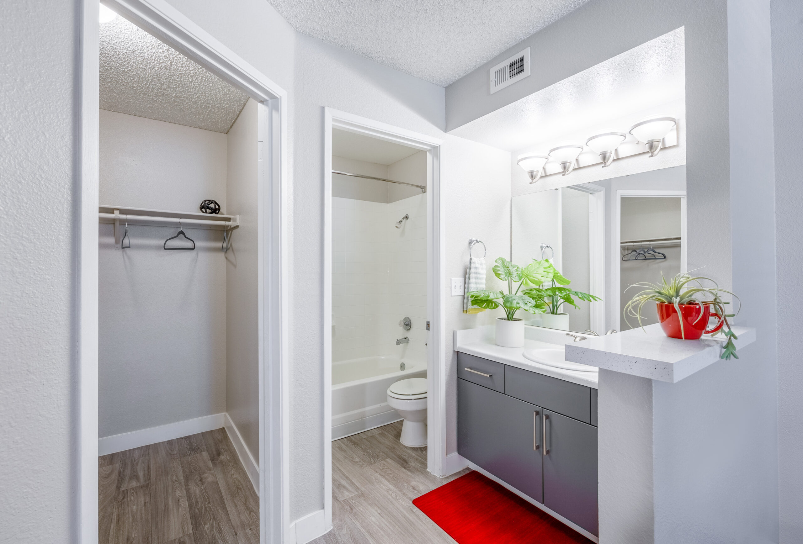 A bathroom featuring a vanity, a separate room with the toilet and tub and another room for a walk-in closet at The Met apartments in Las Vegas