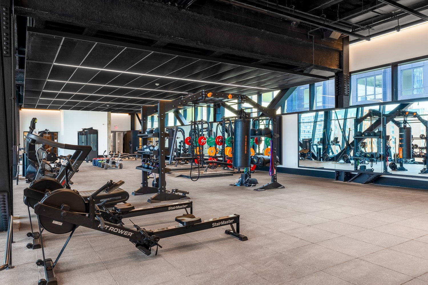 Inside Vela's fitness center top-of-the-line strength training equipment and plentiful light.