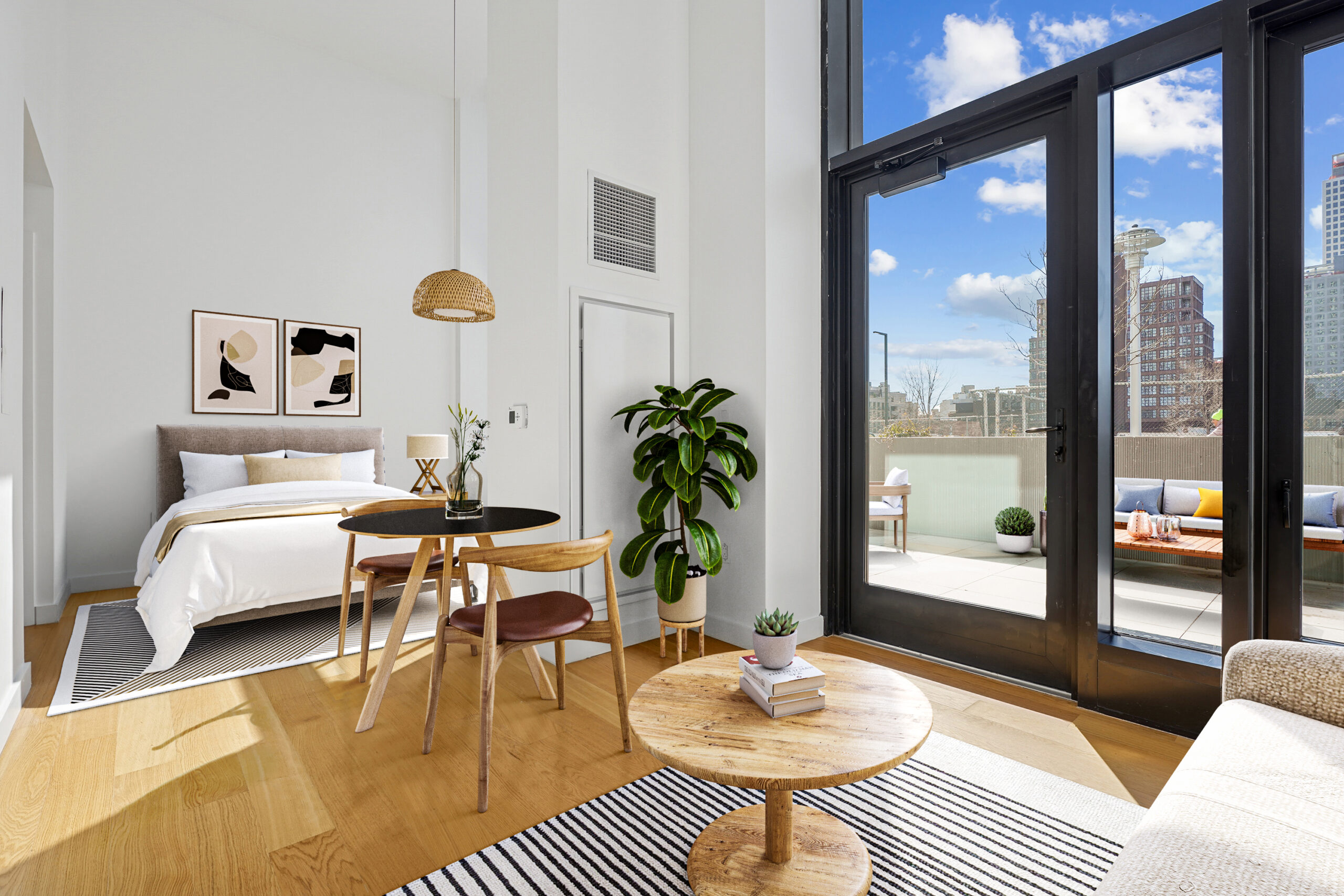 Studio apartment with bedroom, dining, and living areas and a view of the outdoor terrace with furniture.