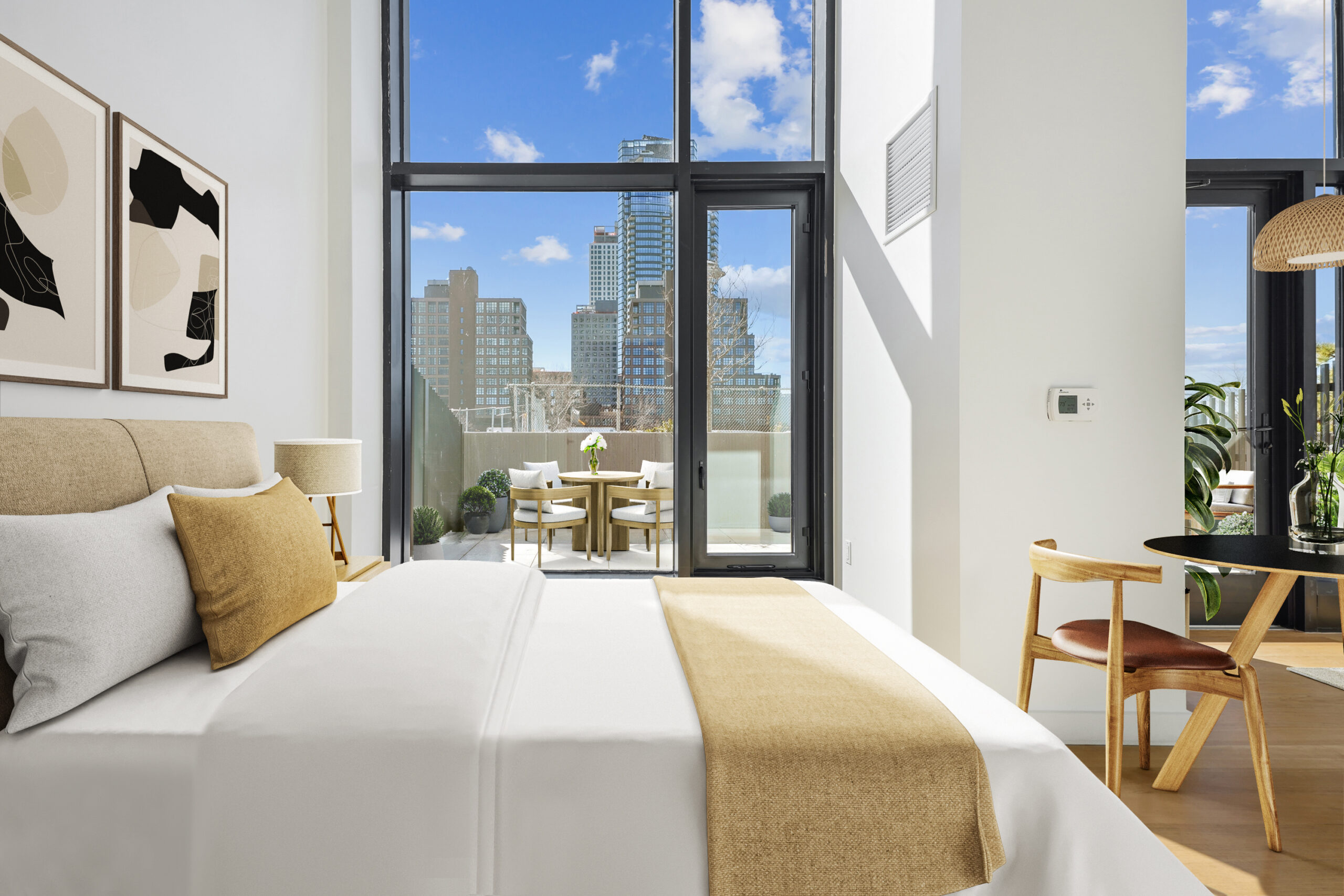 Studio apartment with bedroom, dining, and living areas and a view of the outdoor terrace with furniture.