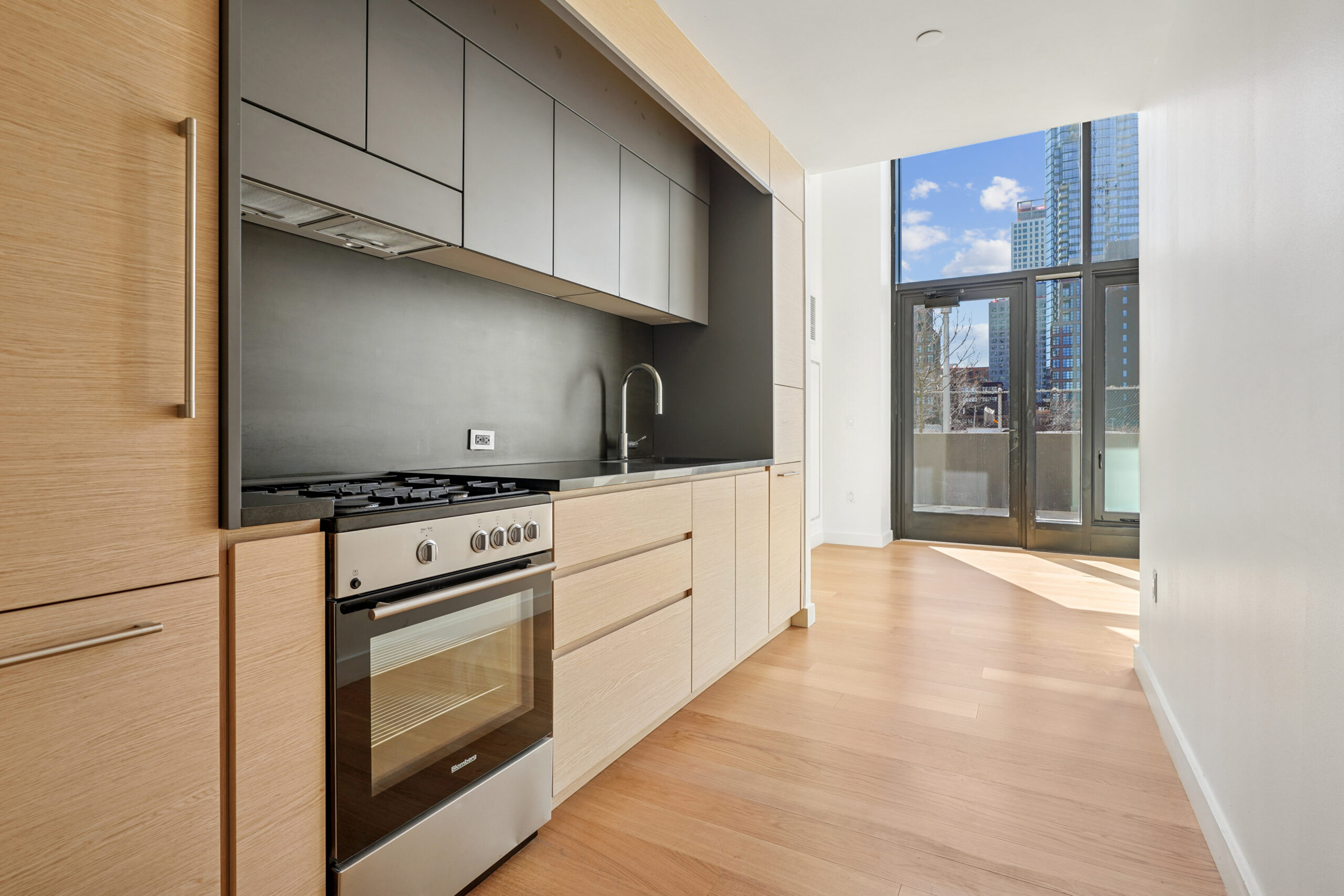 Modern kitchen at Eagle + West with a city view.
