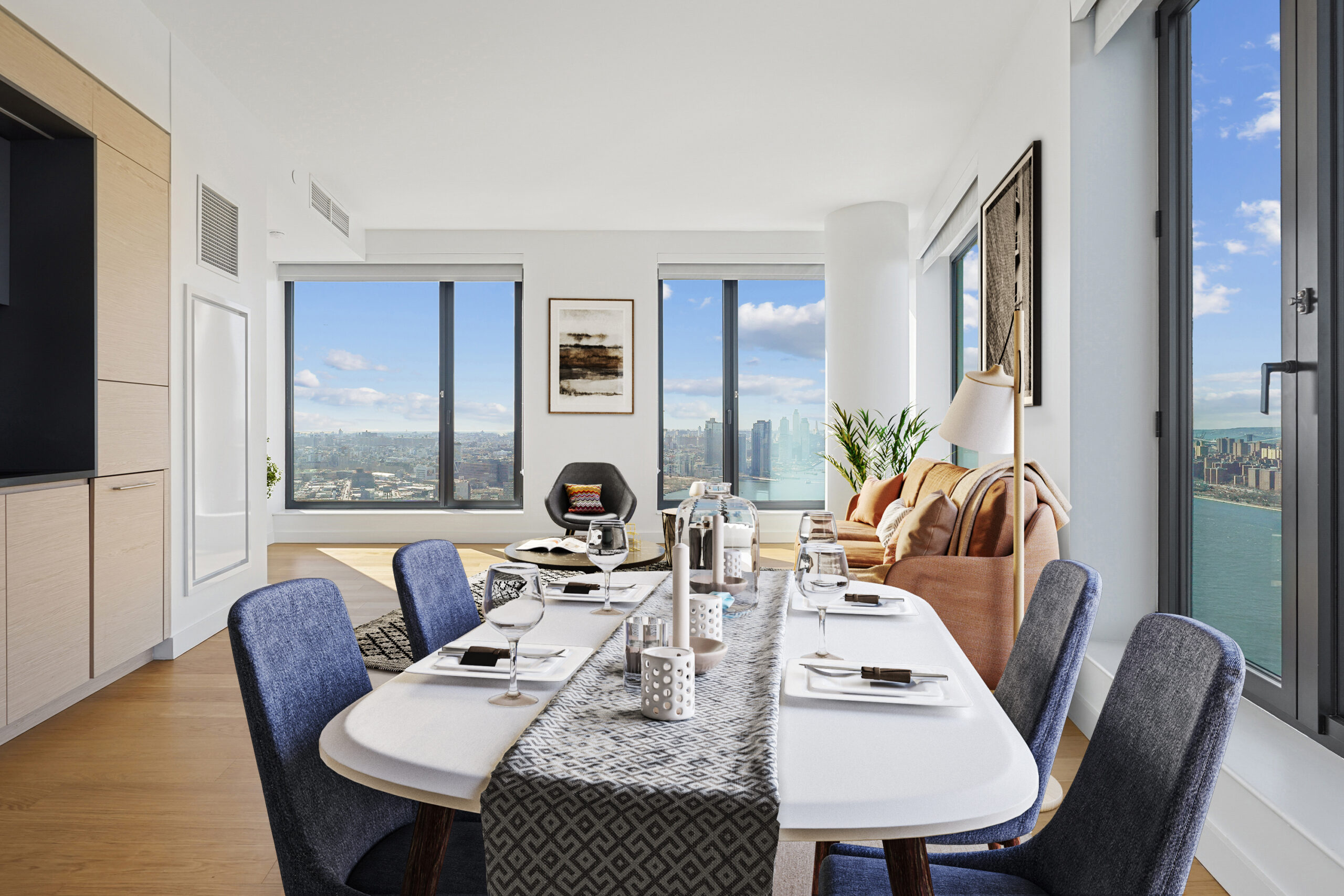 Modern living and dining area with city and water views