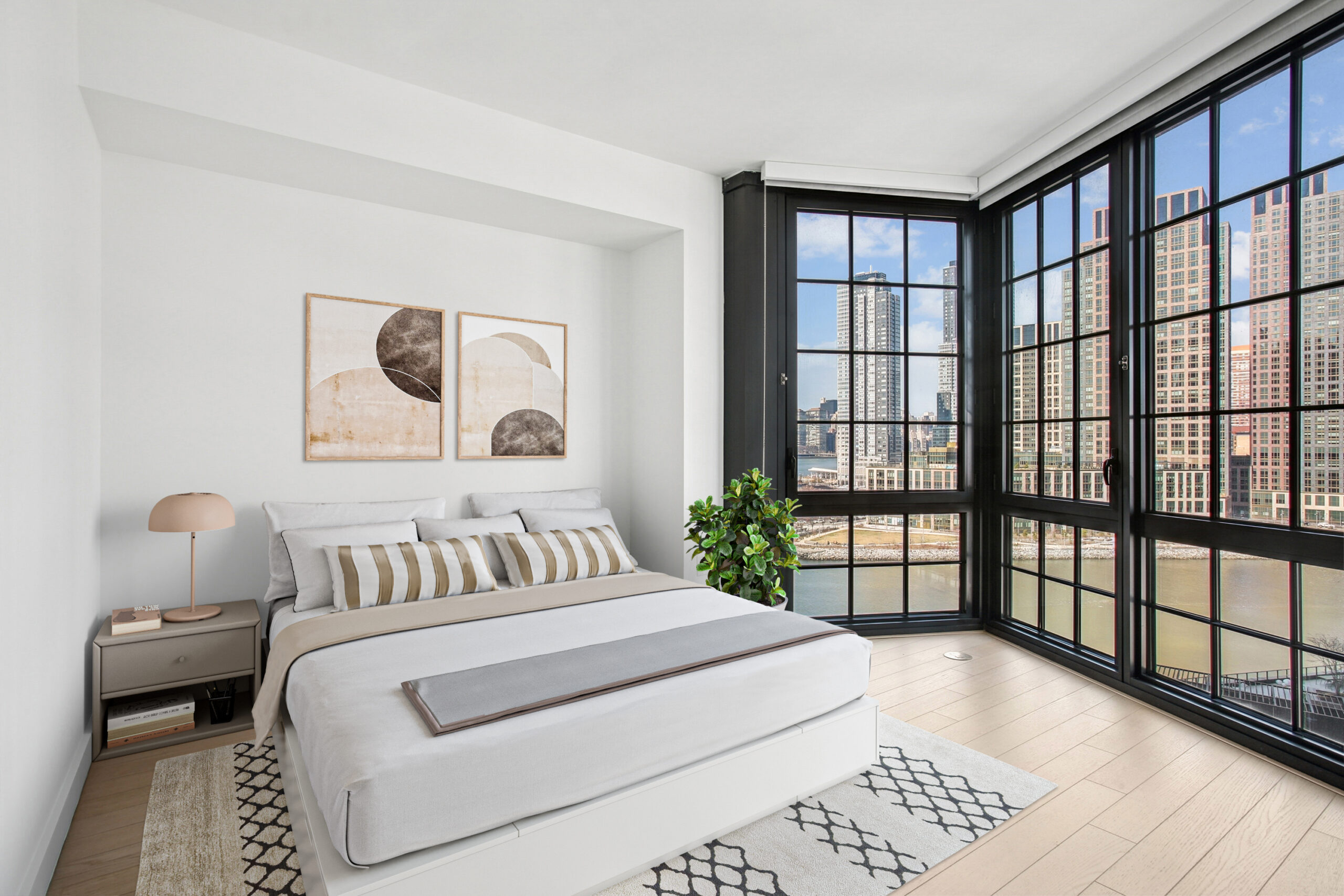 Spacious bedroom with wood flooring and water views