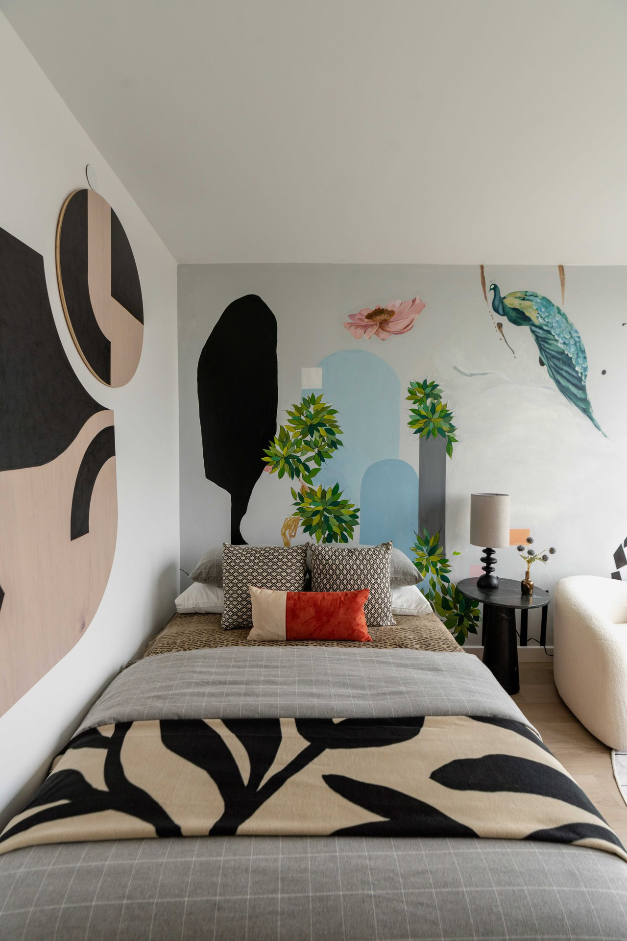 A bedroom with a large bed and a wall mural.