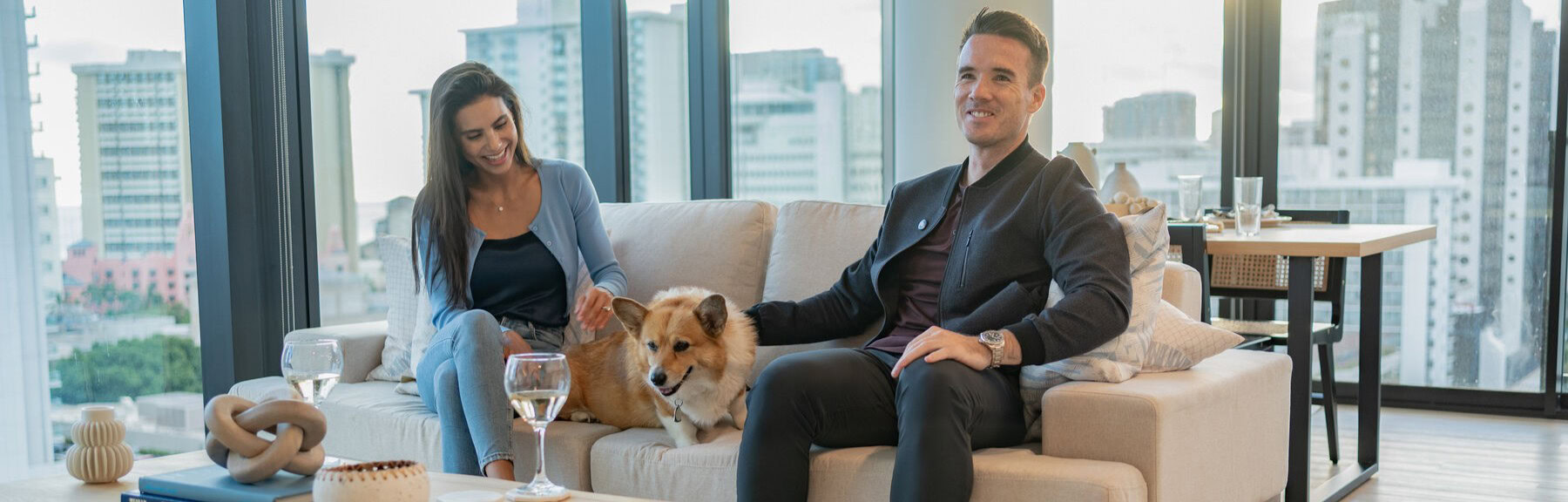 Two people sitting with their dog at lilia apartments in waikiki
