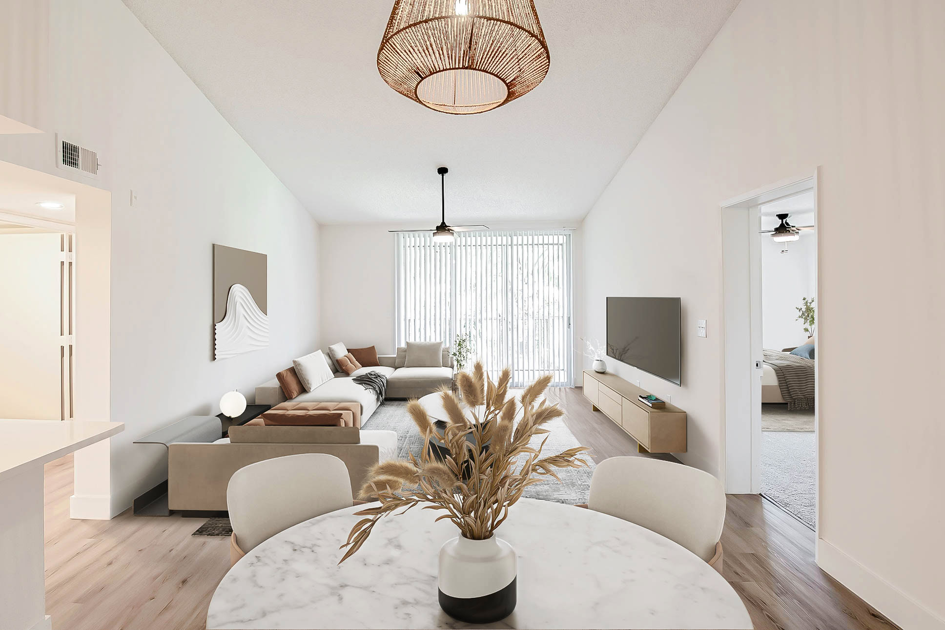 Modern apartment living and dining area with wood-style flooring, high ceilings, and natural light at Miramar Lakes