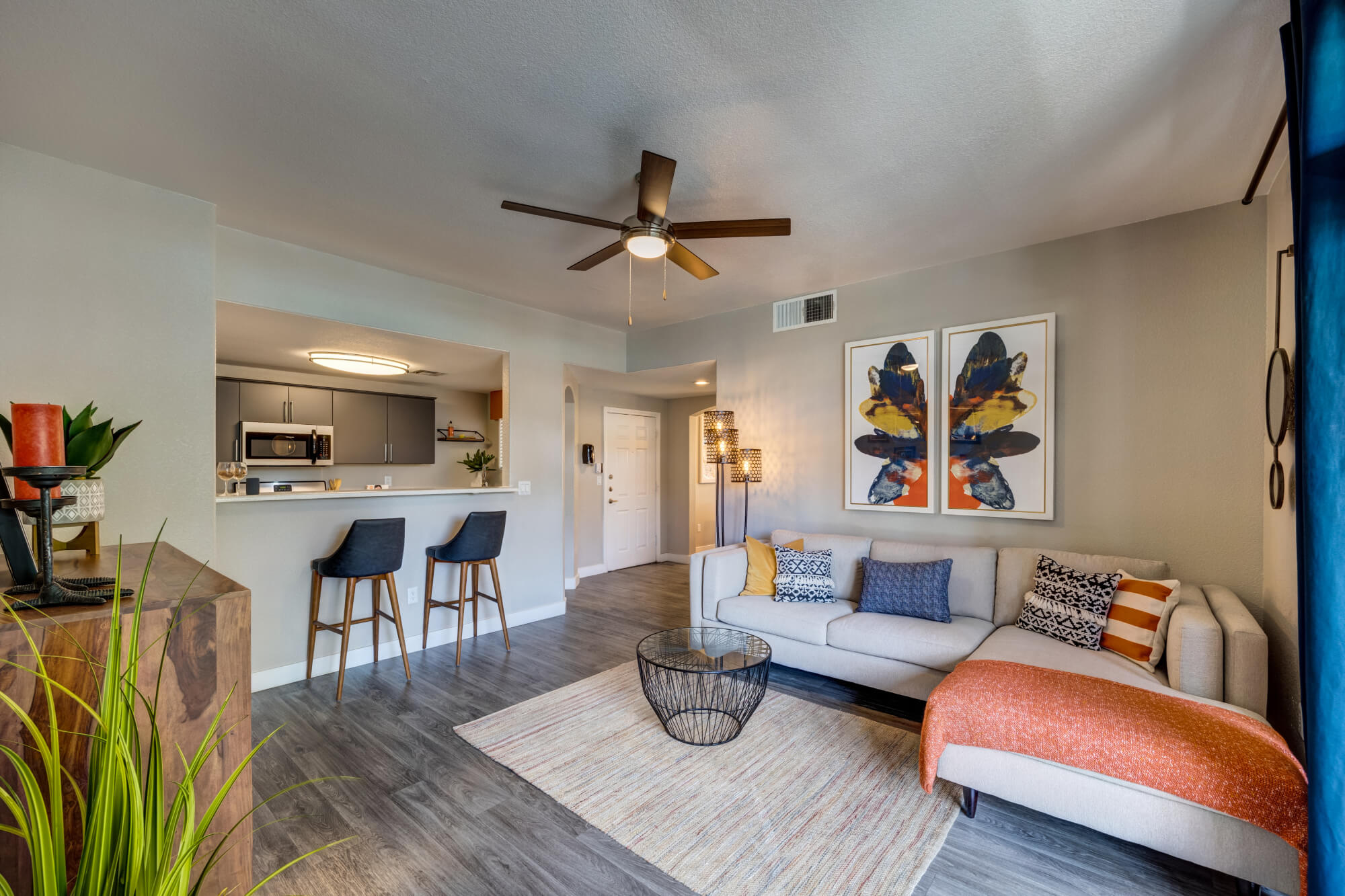 Modern apartment living room with breakfast bar, plank flooring, and neutral finishes at
Monaco Park Apartments.