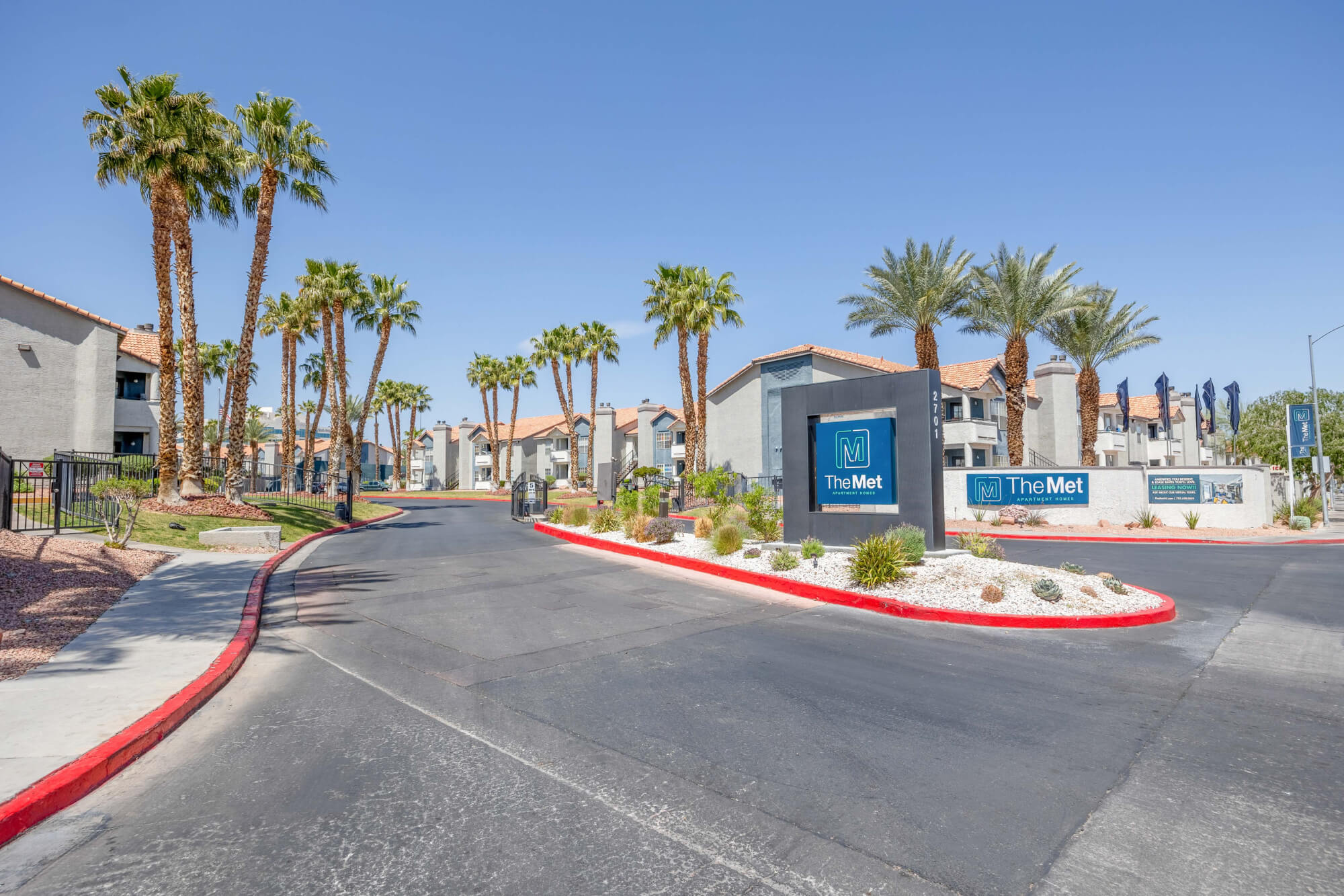 Entrance monument and palm-lined driveway at The Met Las Vegas Apartments in Northwest Las Vegas.