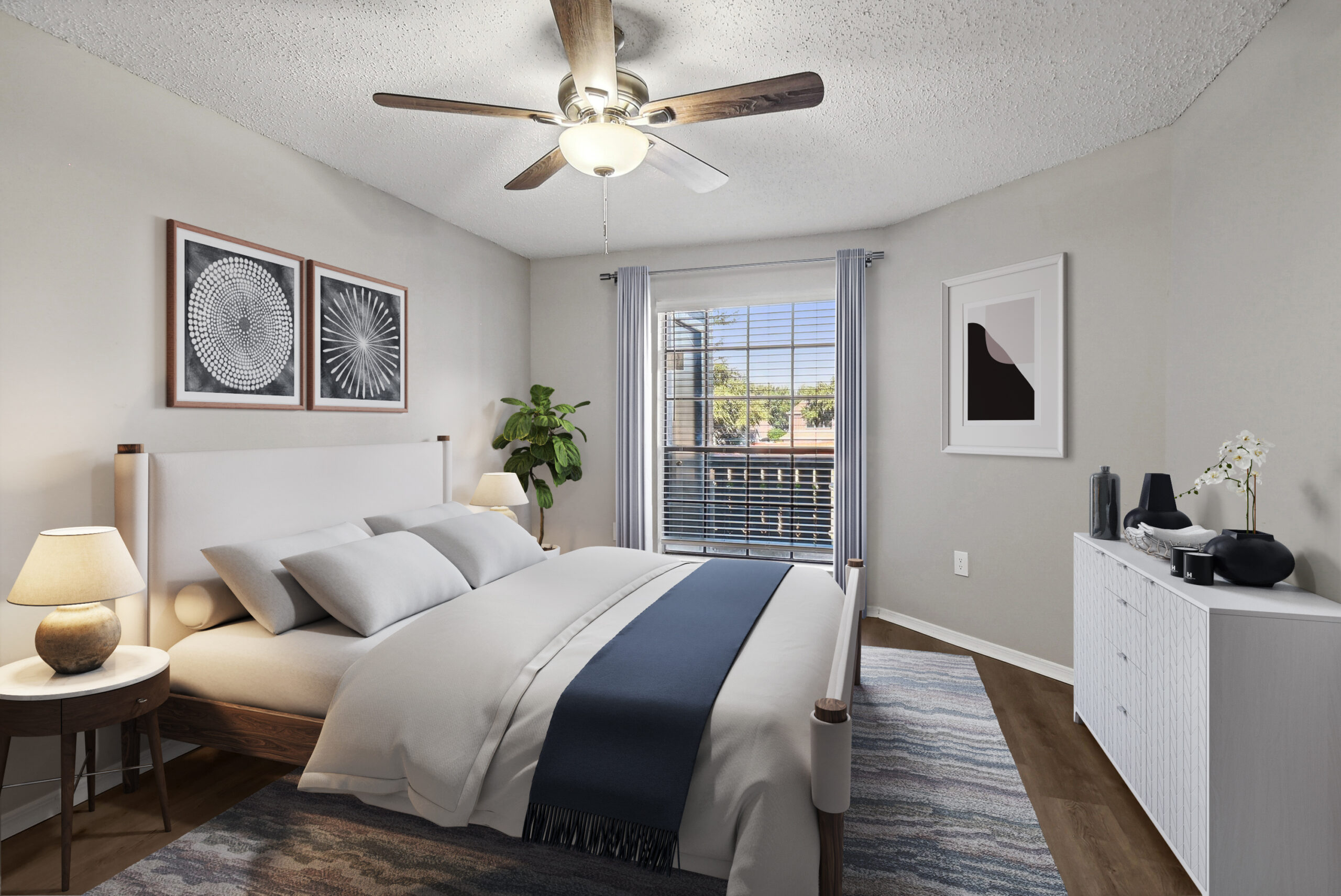 Bright bedroom in apartments in Garland Texas, featuring modern décor, large windows, and wood-style flooring.