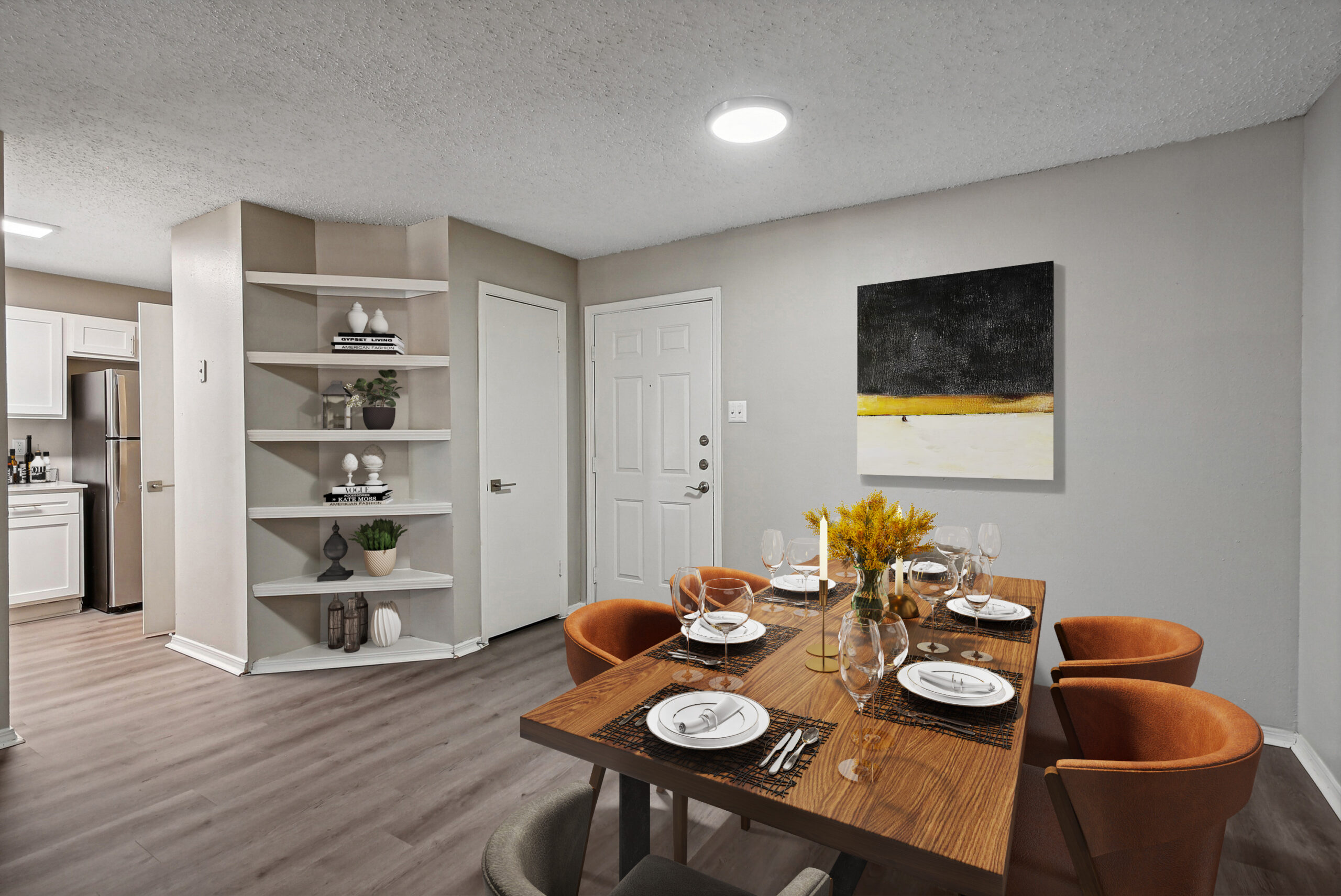 Modern dining area in apartments in Garland Texas near Dallas, featuring wood-style floors, built-in shelving, and contemporary furnishings.