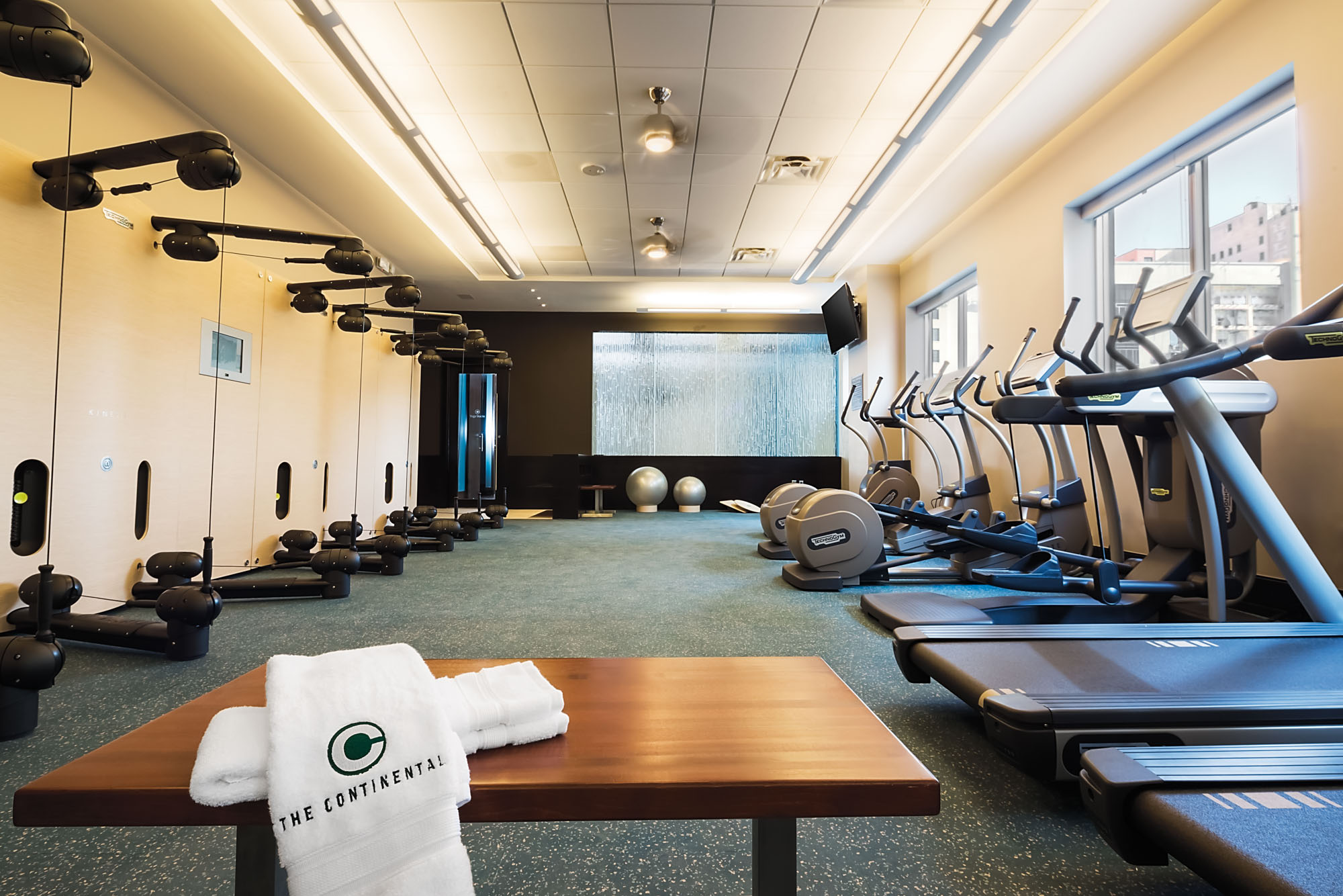 Fitness center at The Continental apartments in Dallas, Texas with cardio machines and weight equipment