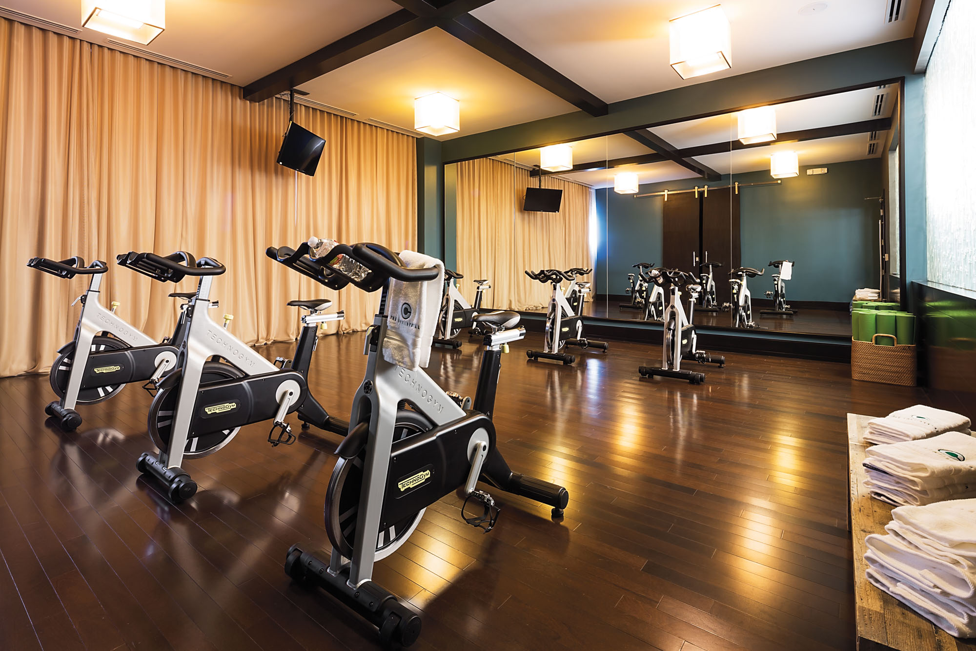Fitness studio at The Continentals apartments in Dallas, Texas featuring spin bikes in two rows of three