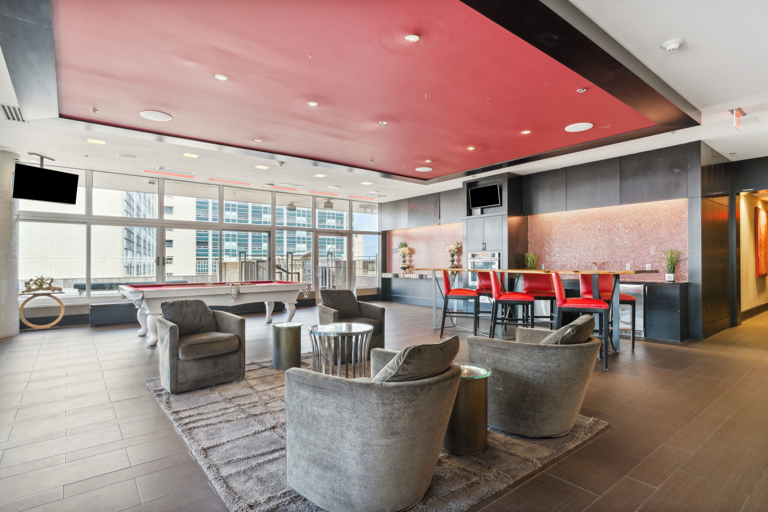 Bright modern rooftop lounge at The Continentals apartments with seating, high tables, a pool table and kitchen area