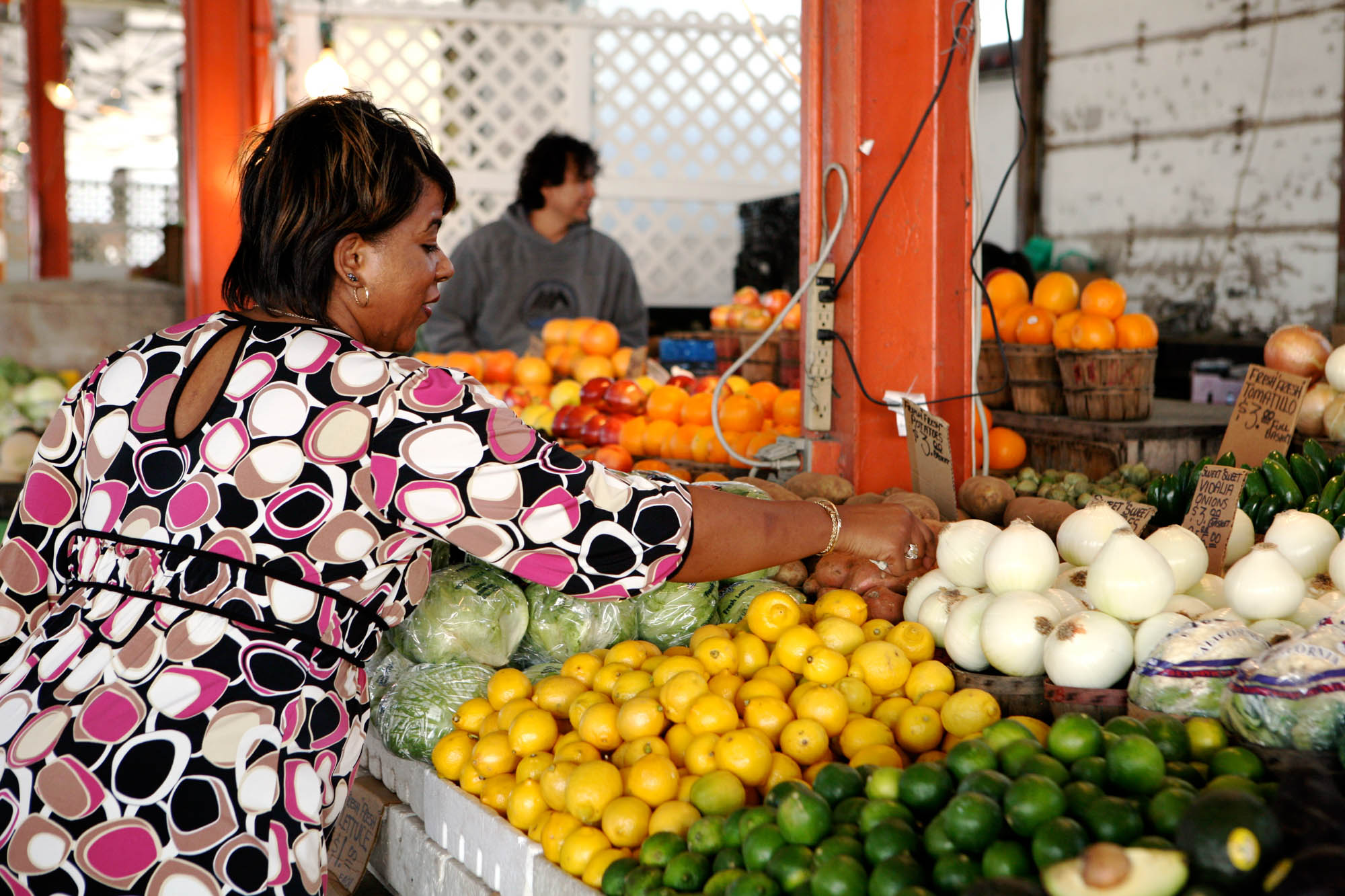 A woman picking out onions at the Farmers Market near The Continental apartments in Dallas, Texas