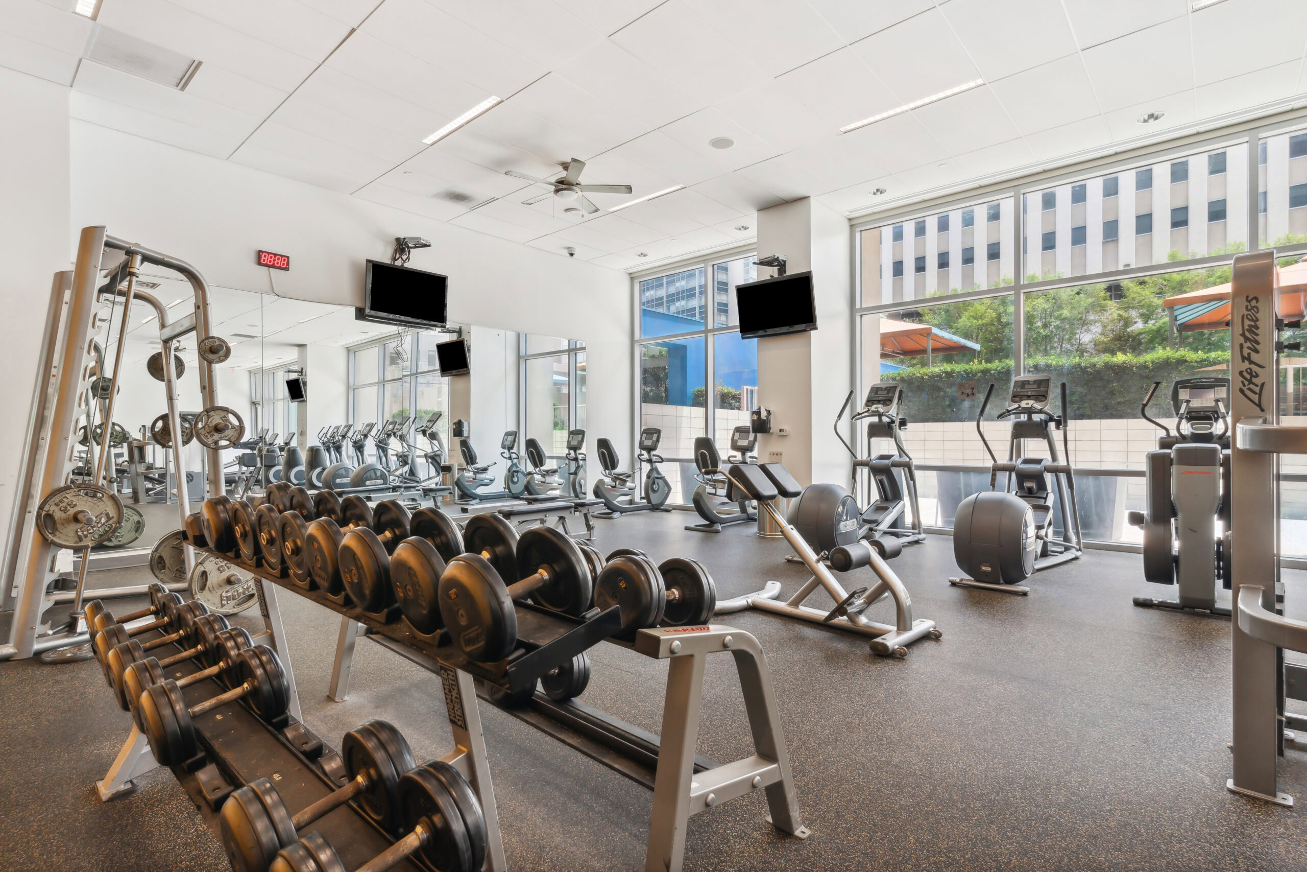 A fully equipped fitness center with ellipticals, weight machines and weights at The Element in Dallas Texas