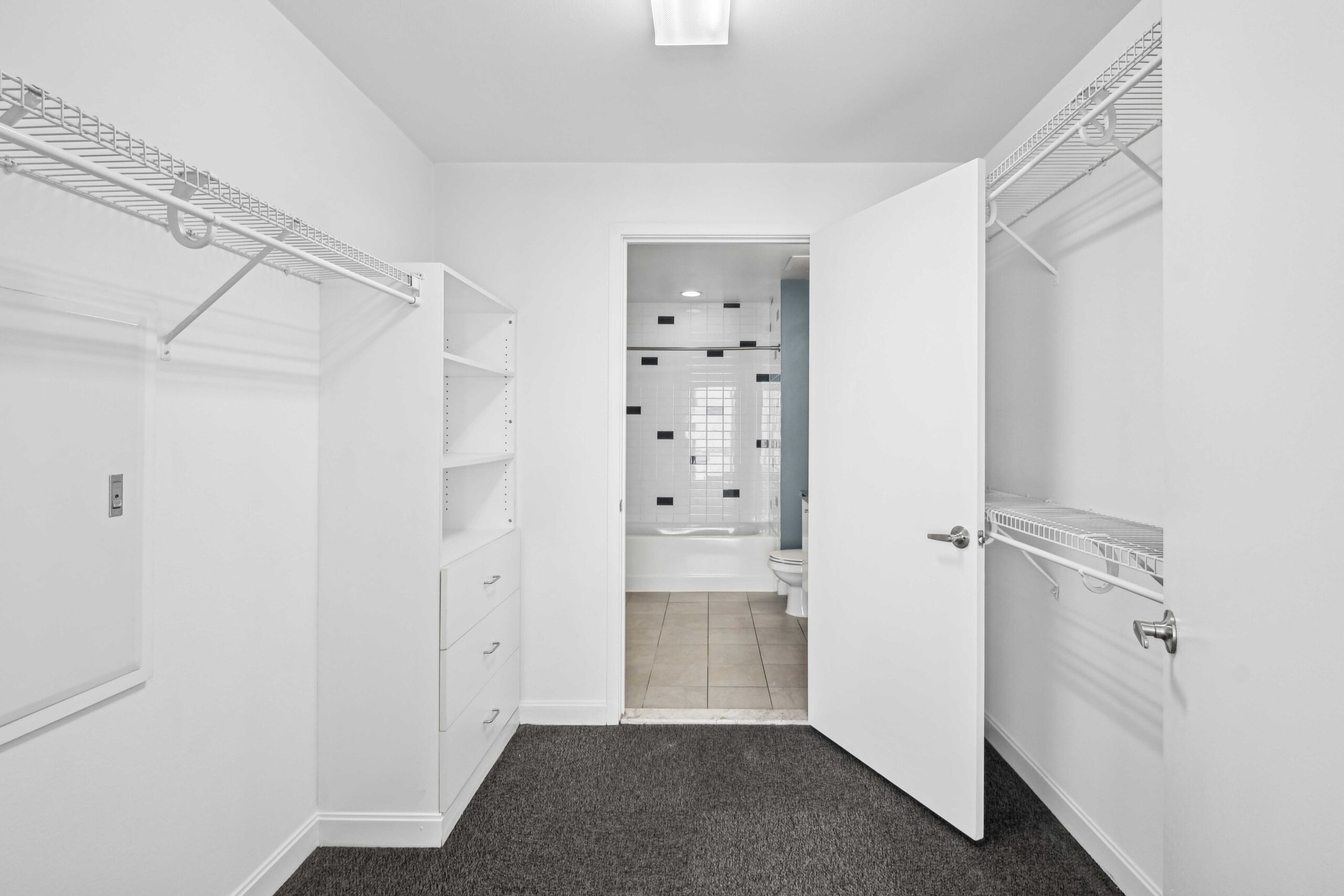 Spacious all white walk-in closet with ample storage space in an apartment at The Elements in Dallas Texas