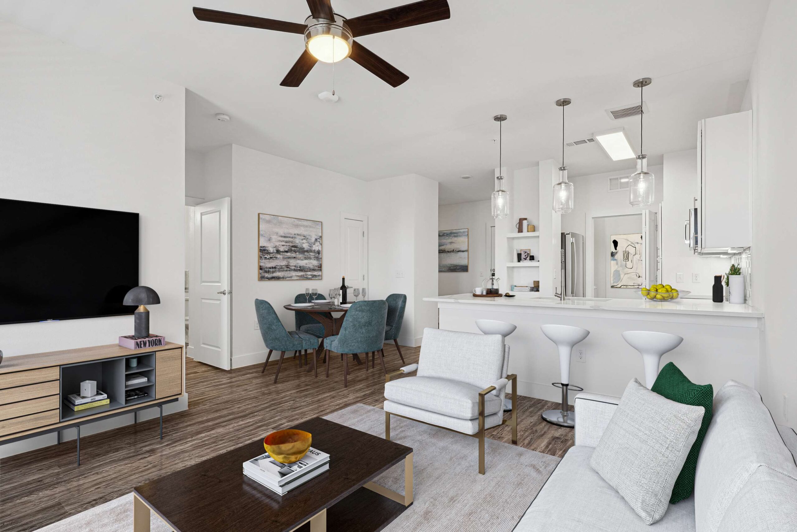 Open-concept living and dining area in apartments in Garland Texas featuring modern finishes, wood-style floors, and a bright kitchen with pendant lighting
