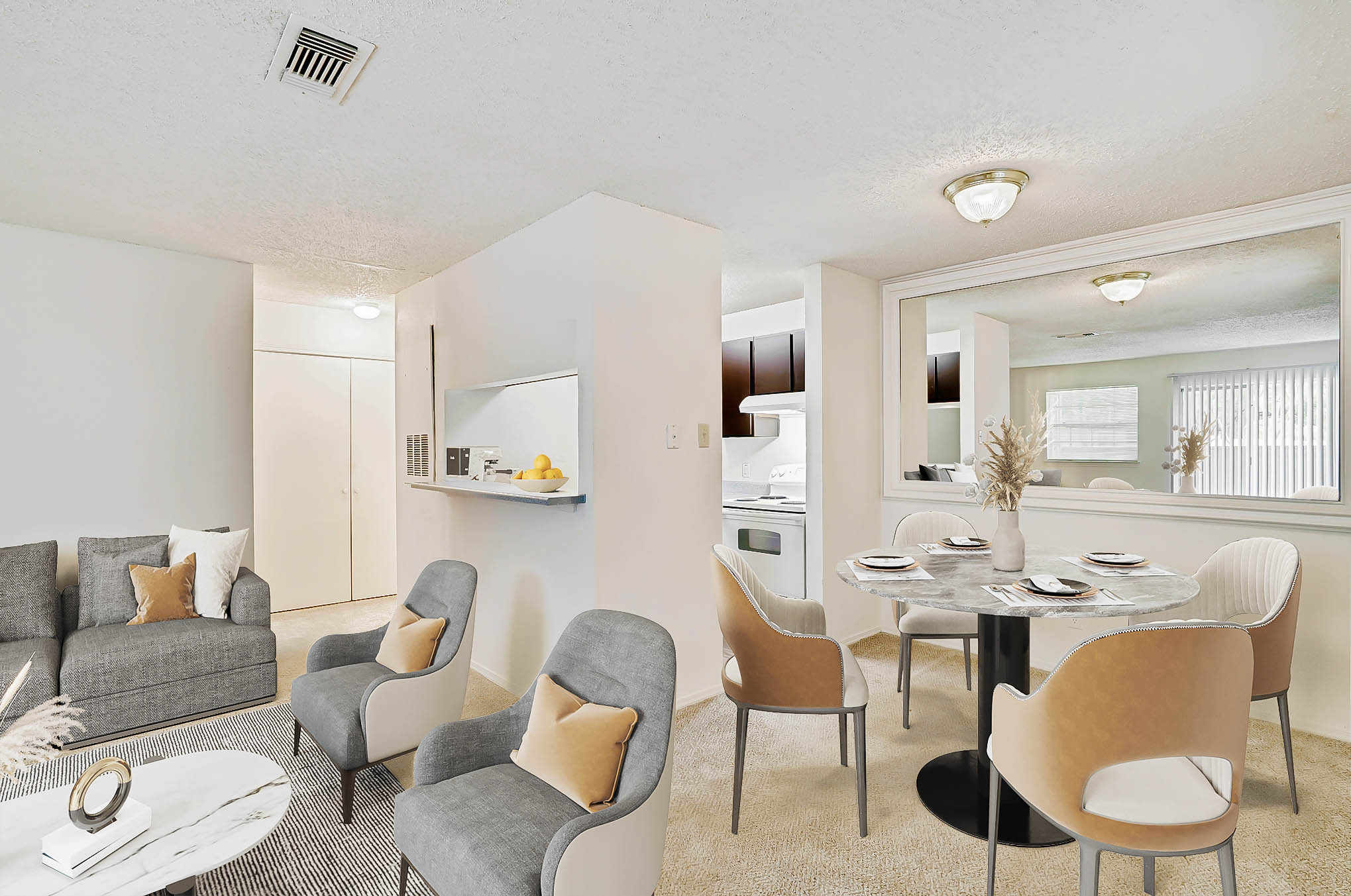 Bright living and dining area in a Mckinney Texas apartment, featuring neutral décor, carpeted flooring, and a pass-through kitchen window.
