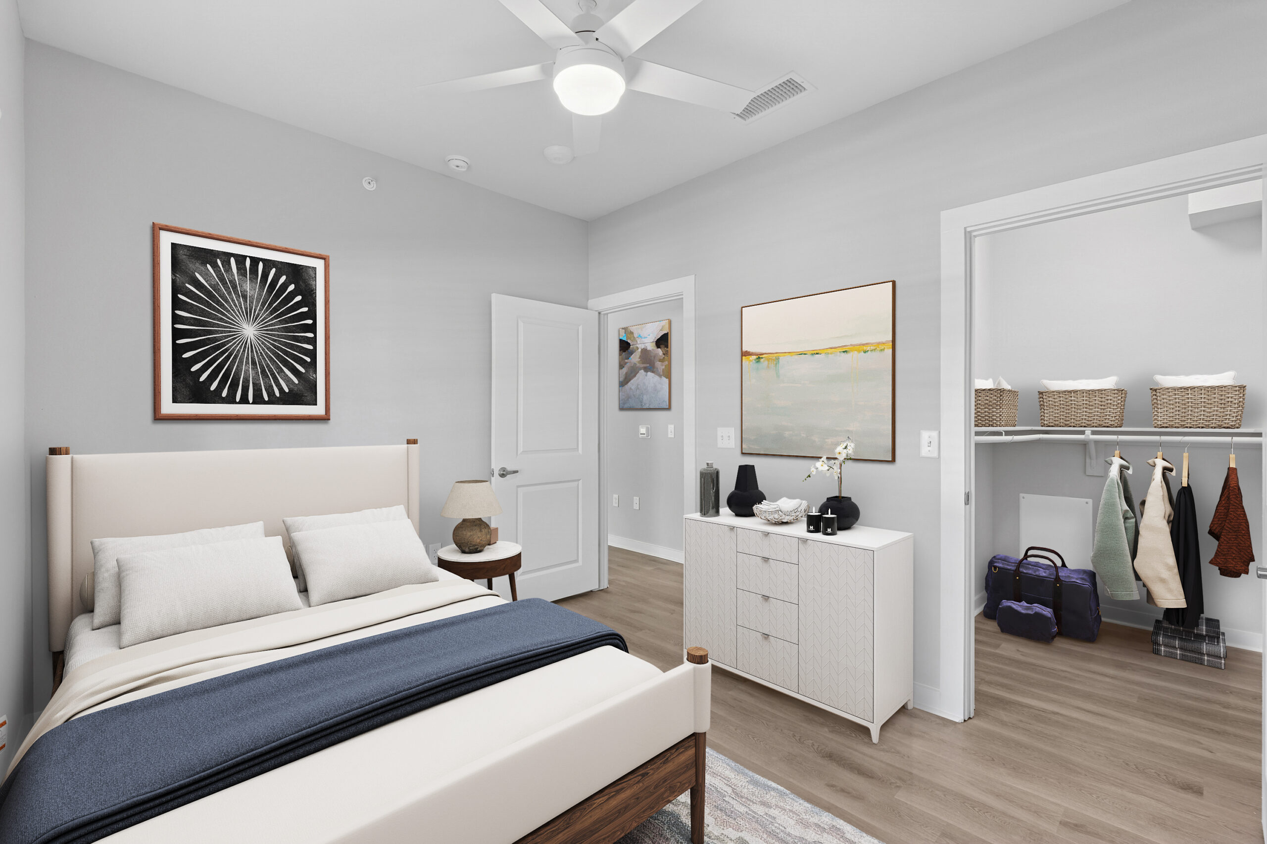 Modern bedroom in a Mckinney Texas apartment featuring a neutral color palette, large walk-in closet, wood flooring, and contemporary furnishings