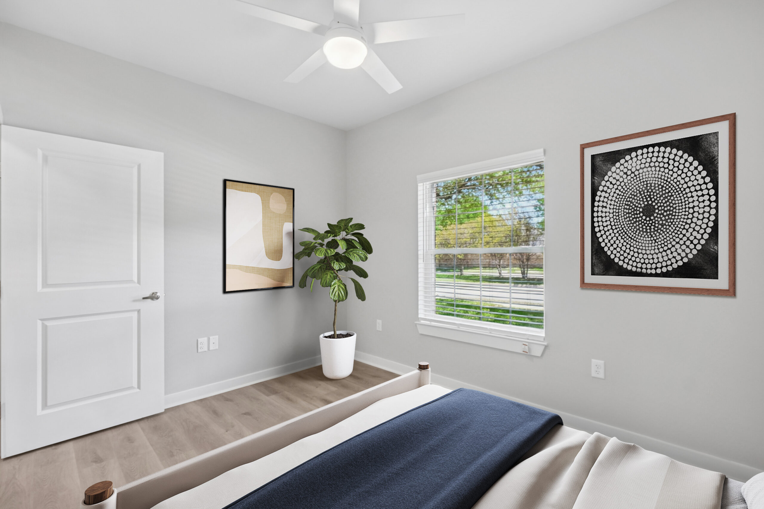 Bright modern bedroom in Mckinney Texas with large window, minimalist artwork, wood floors, and natural light.