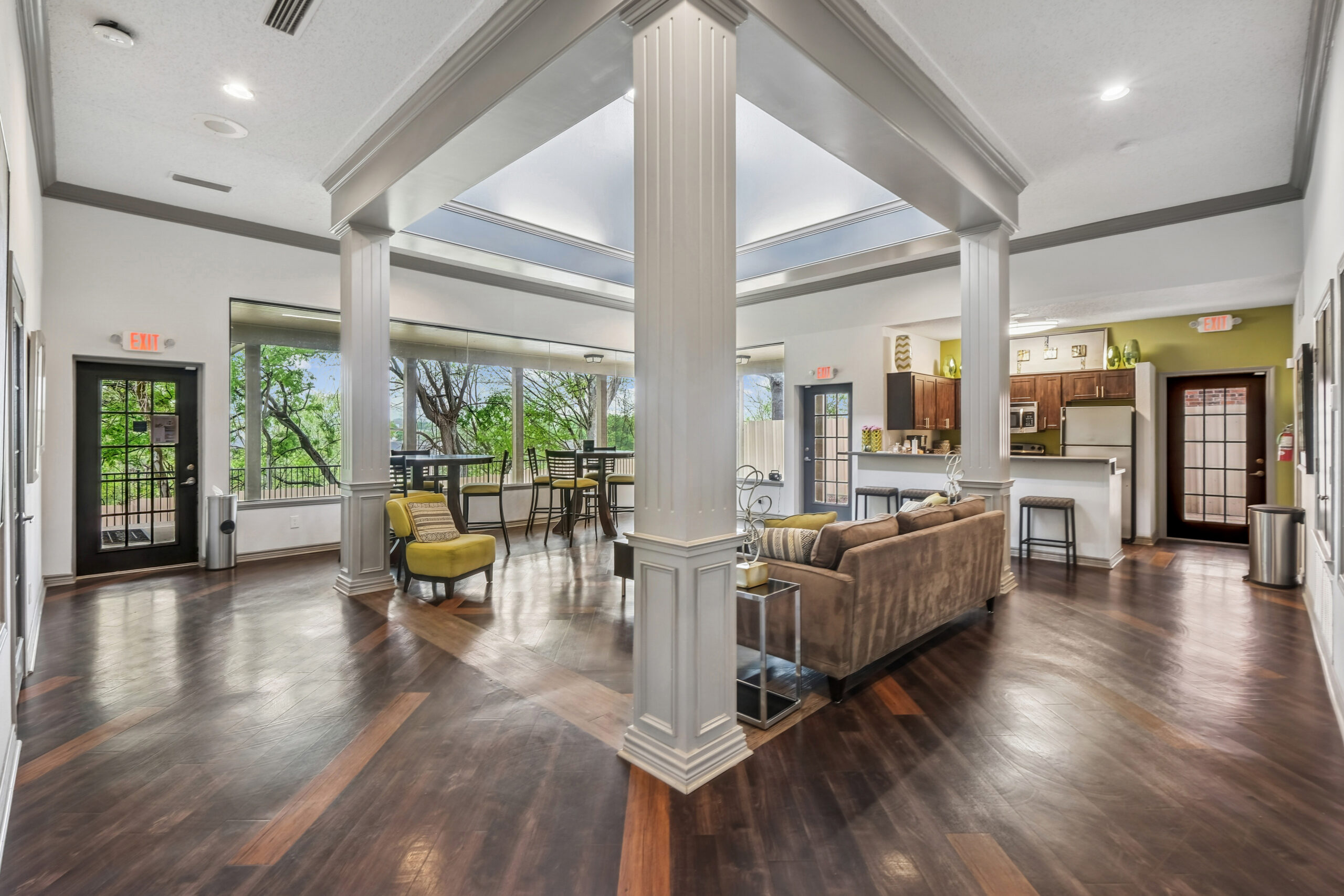 Spacious resident clubhouse at the Gables of Mckinney apartments in Mckinney Texas featuring large windows, modern lounge seating, and an open community kitchen.