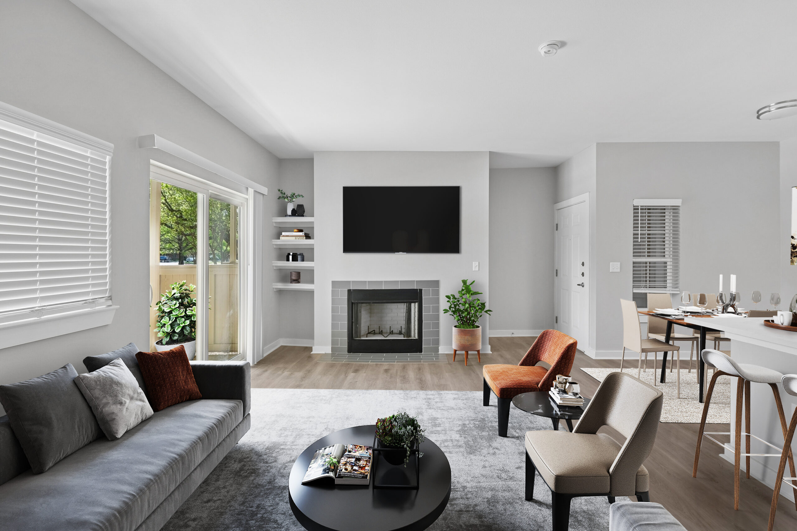 Living room in a Mckinney Texas apartment with a modern fireplace, large windows, wood-style flooring, and open dining area.