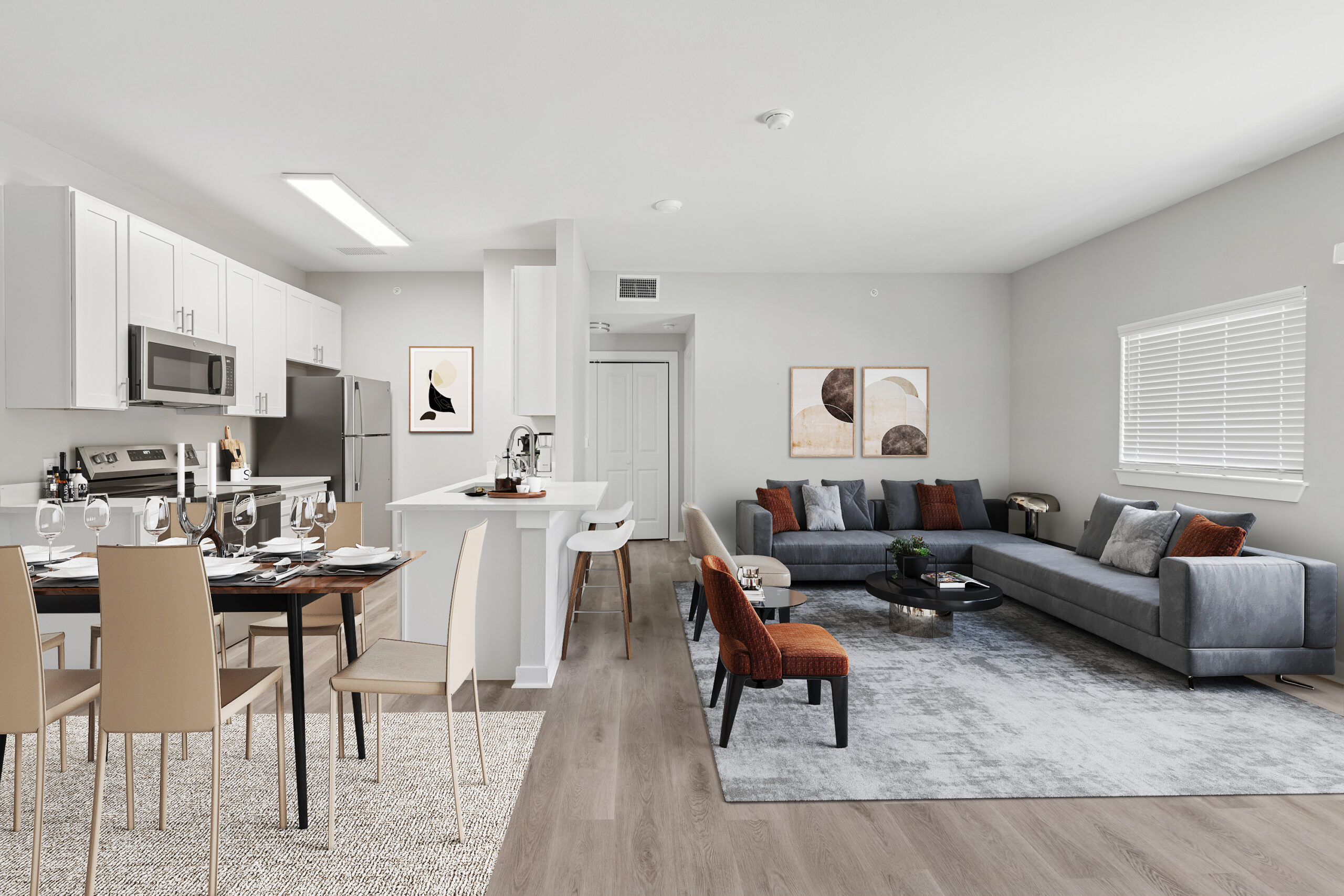 Open-concept apartment interior featuring a modern white kitchen, dining area, and spacious living room with contemporary furniture and wood flooring.