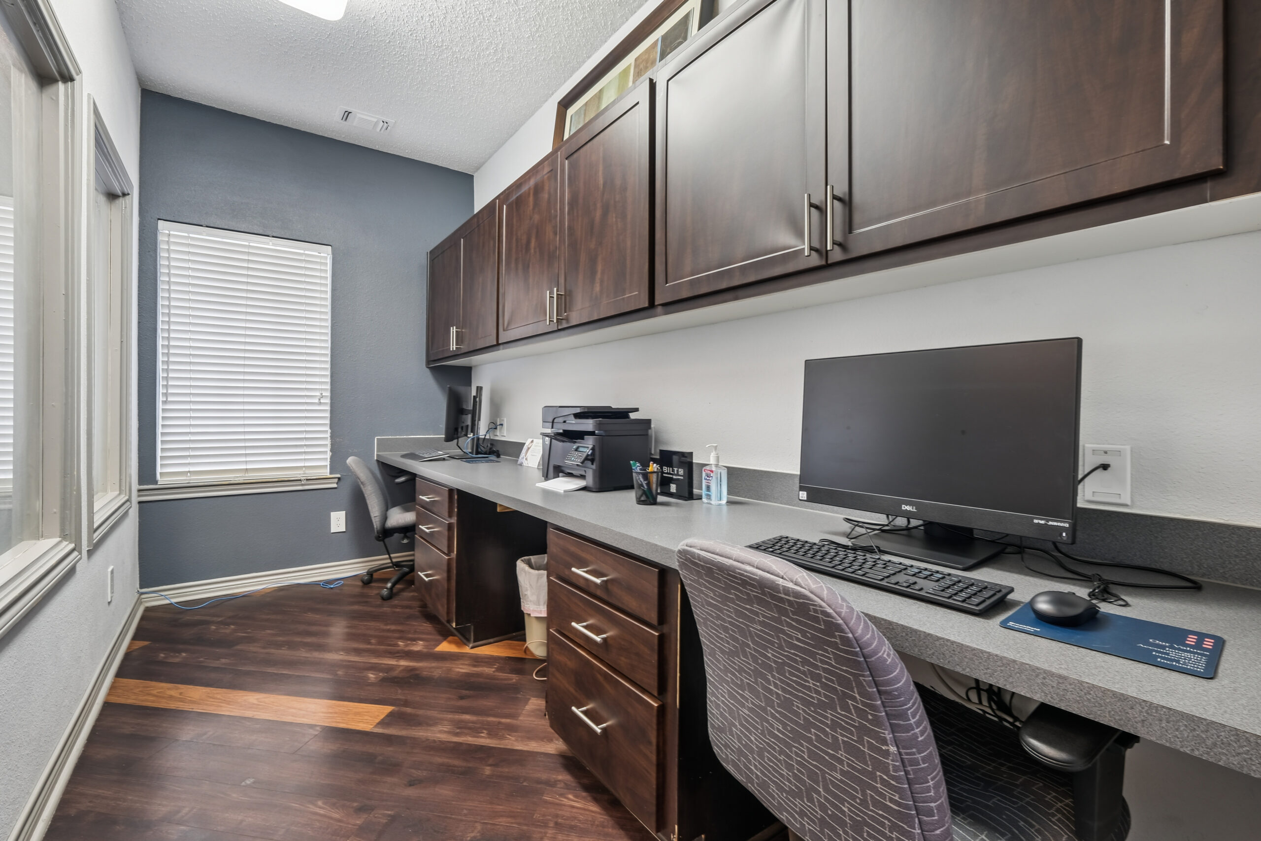 Resident business center at Mckinney Texas apartments with computers, seating, and built-in workspace.