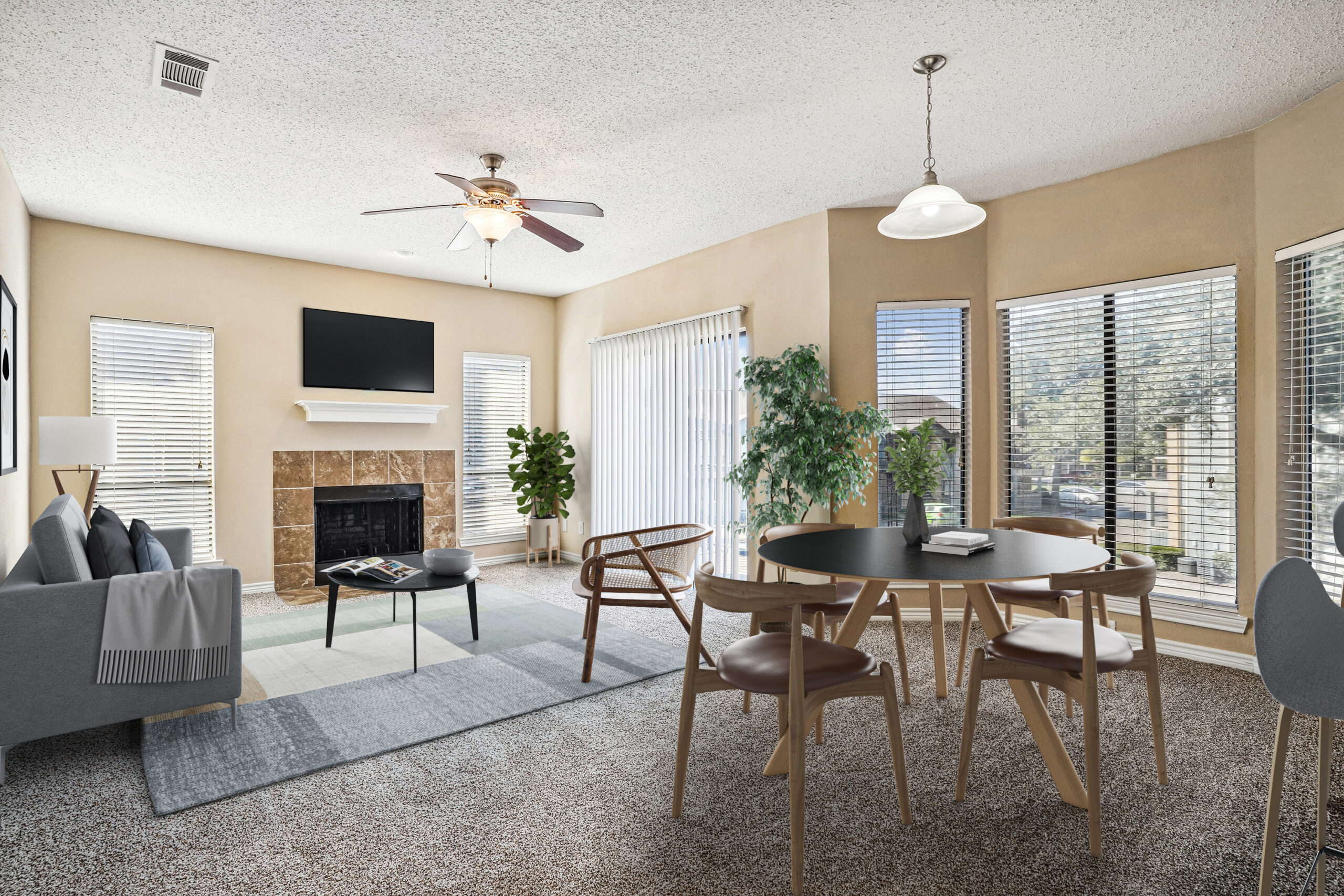 Bright, furnished living and dining area in apartments in Garland Texas, featuring a fireplace, large windows, and cozy carpeted flooring