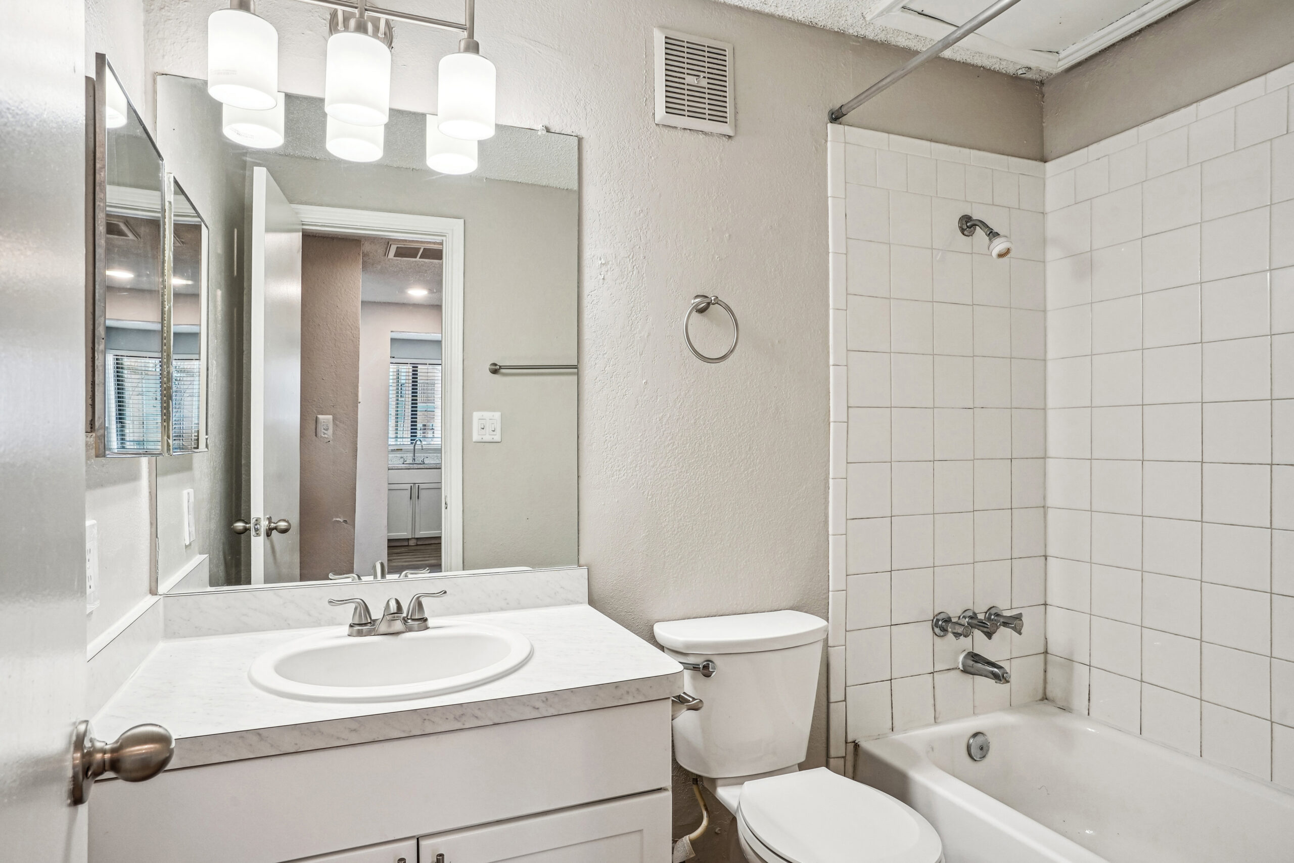 Garland Texas apartment bathroom with a sink and vanity and white tile walls in the tub area