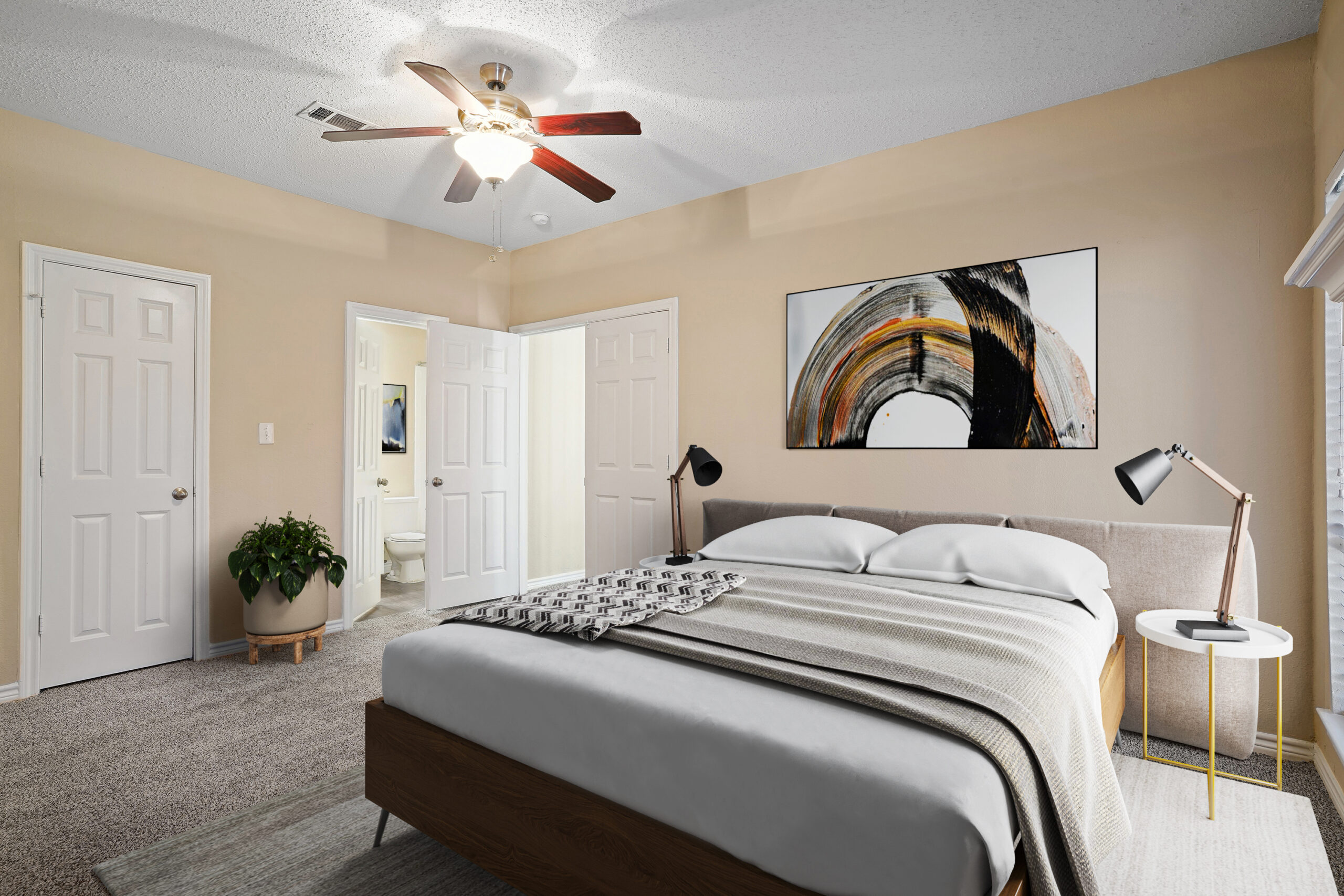 Spacious, bedroom in a Garland Texas apartment, featuring soft carpeting, natural light, and an ensuite bathroom.