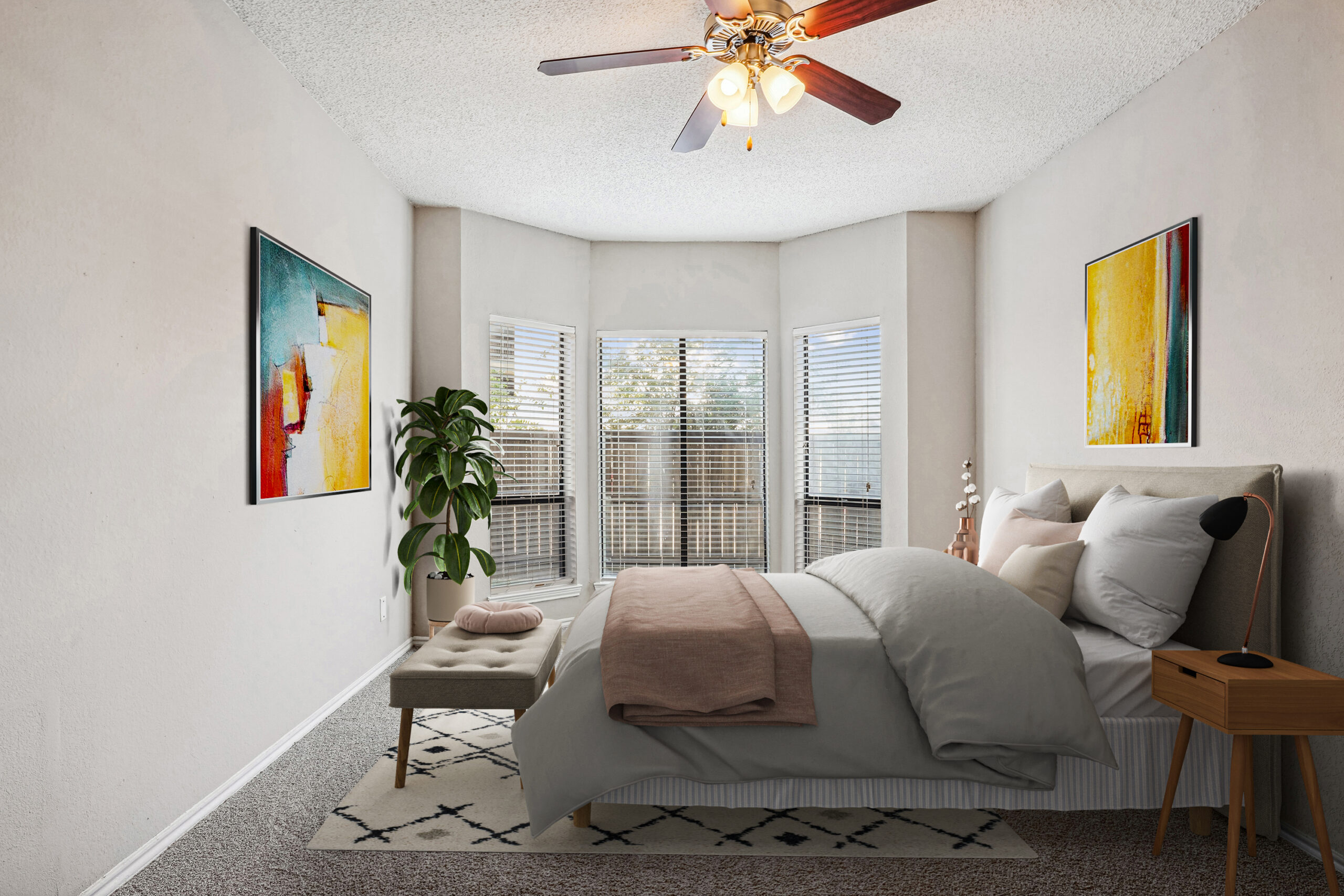 Cozy bedroom in a Garland Texas apartment, featuring large bay windows, soft carpeting, contemporary furniture and bright wall art