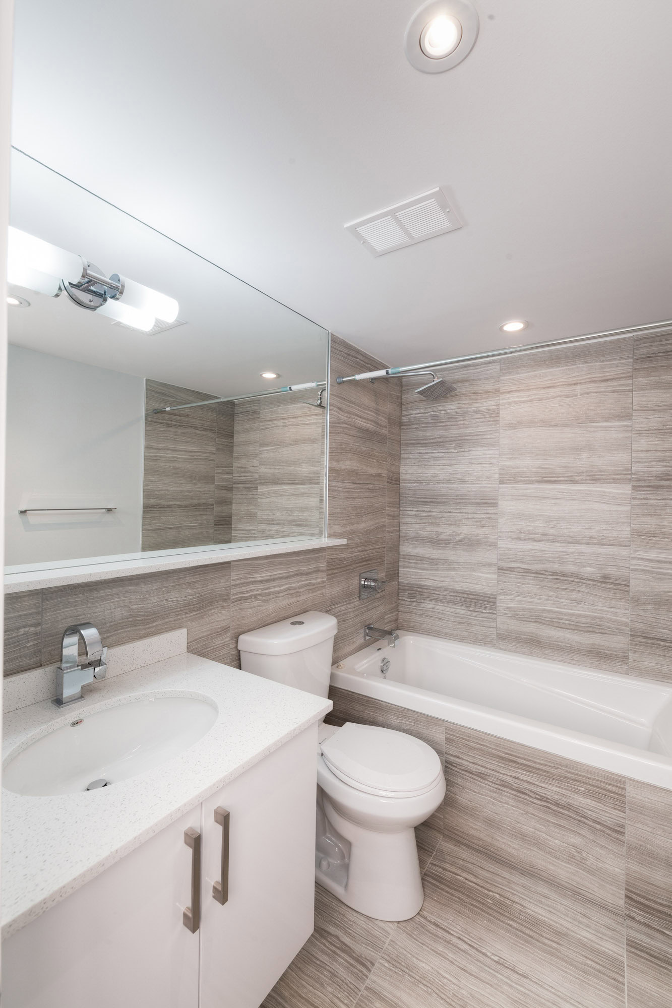 A bathroom with a tub and shower head at the 77 Davisville Toronto apartments for rent