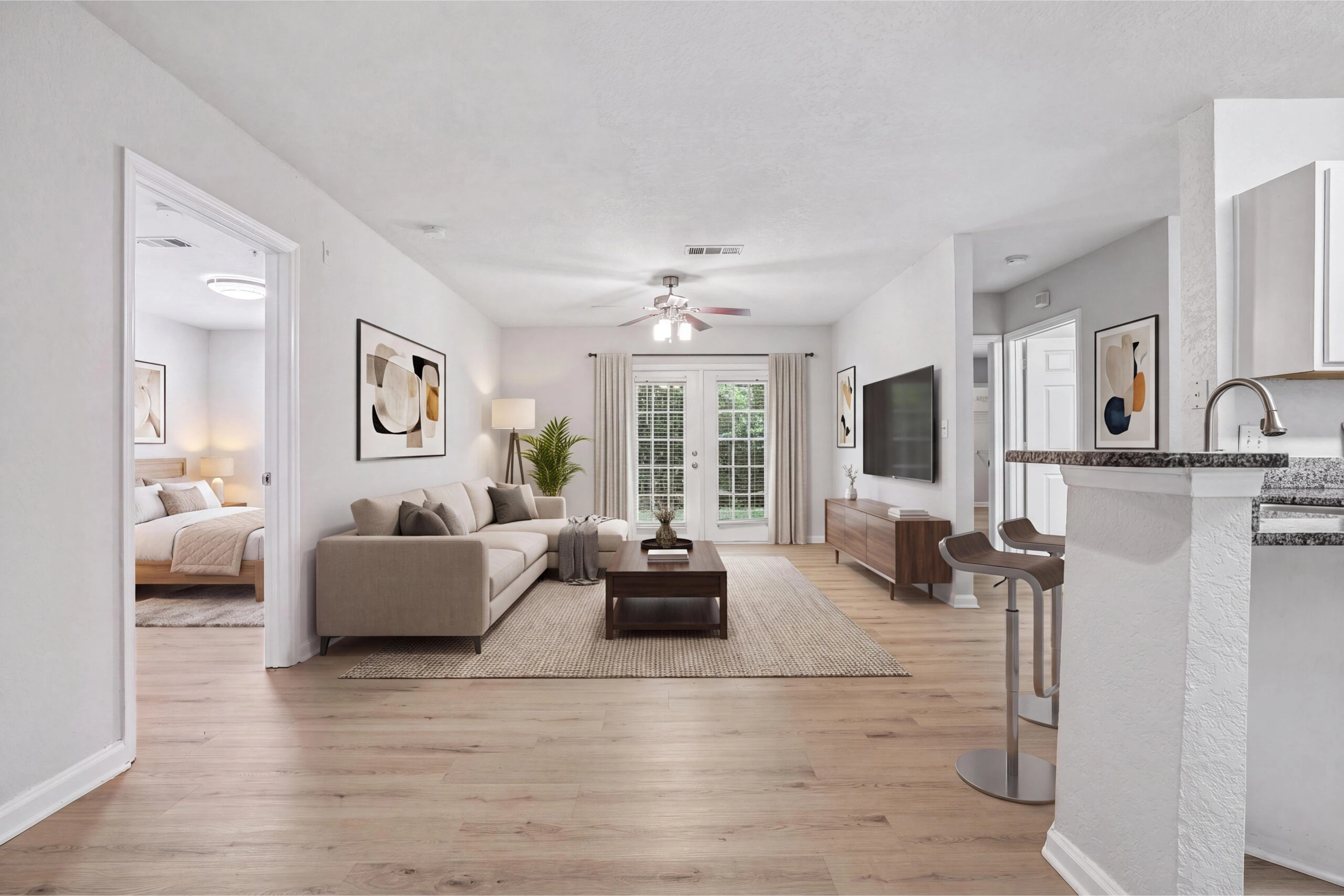 Spacious, open-concept living room with natural lighting, hardwood plank flooring, and modern features