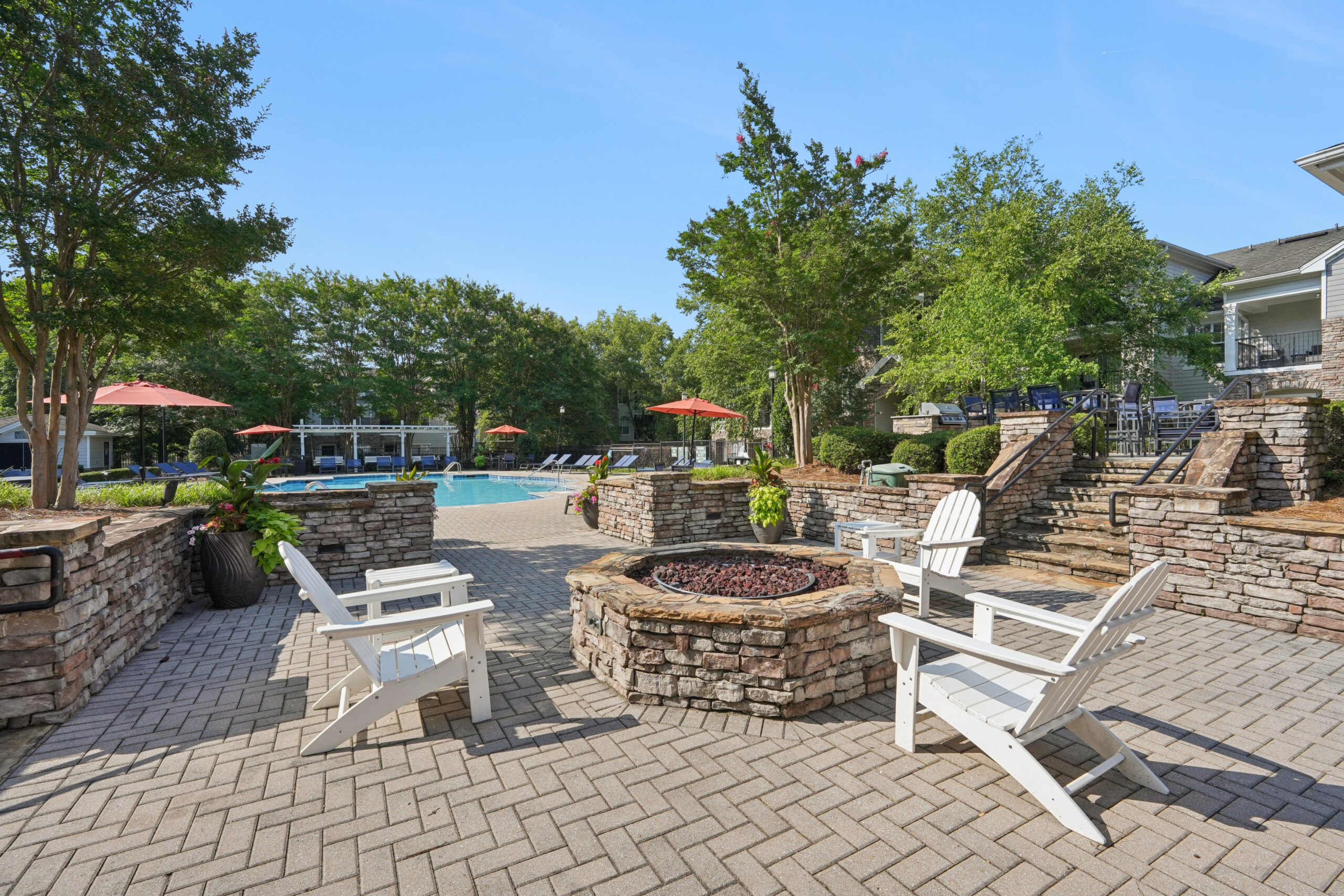 Firepit lounge area alongside sparkling outdoor pool