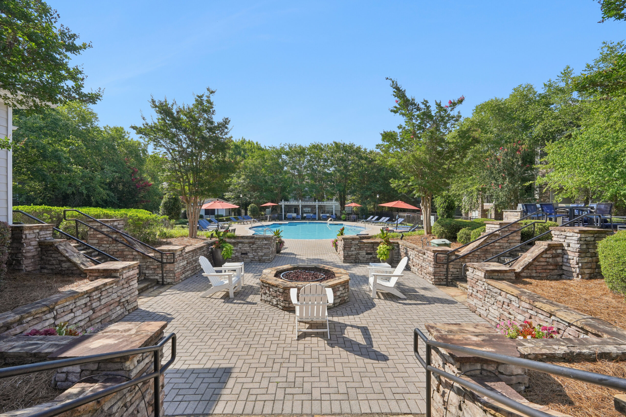 Outdoor pool with firepit, grills, and ample lounge seating