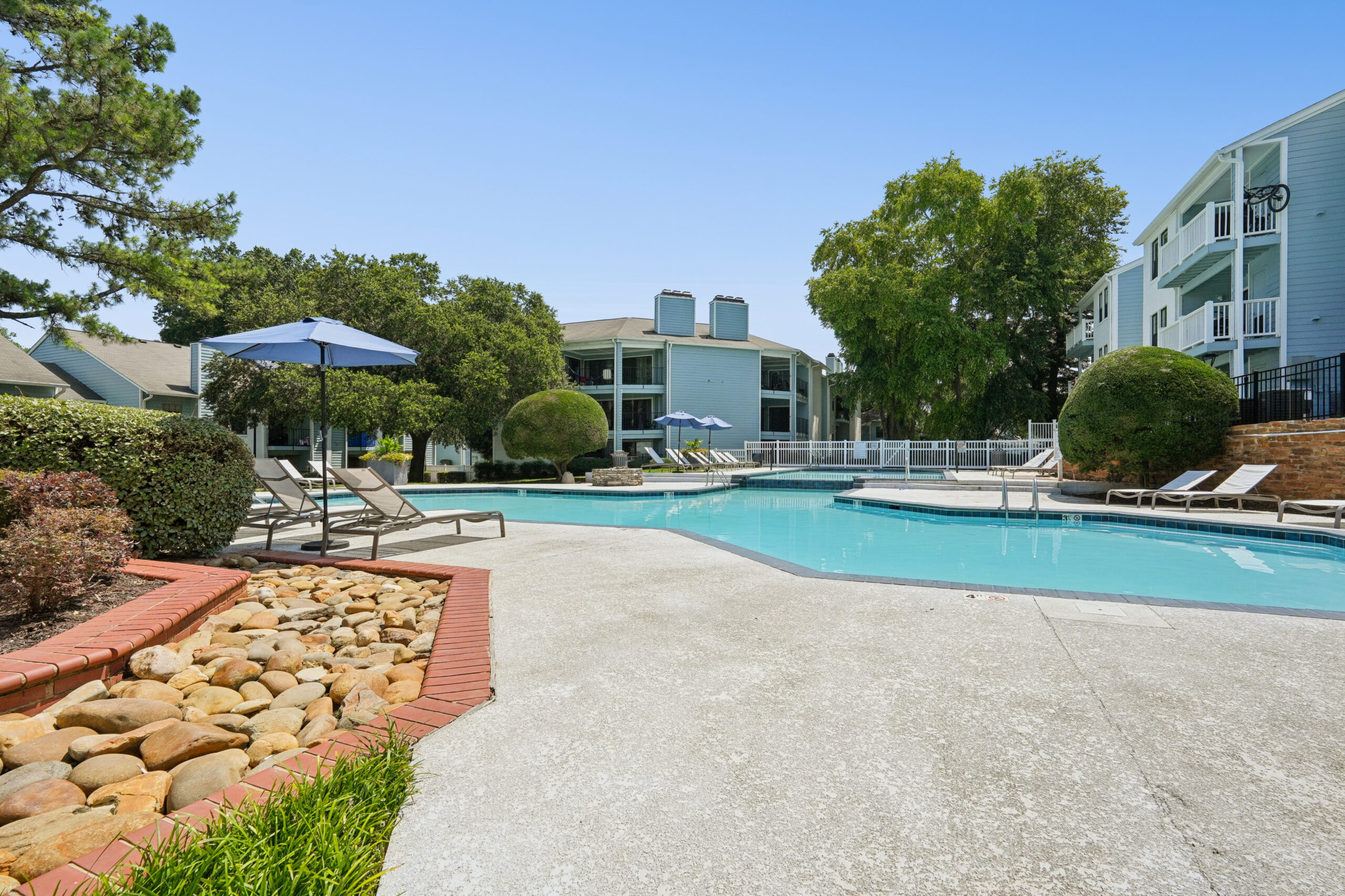 Outdoor resort-style pool with sundeck and lounge seating to relax and cool off.