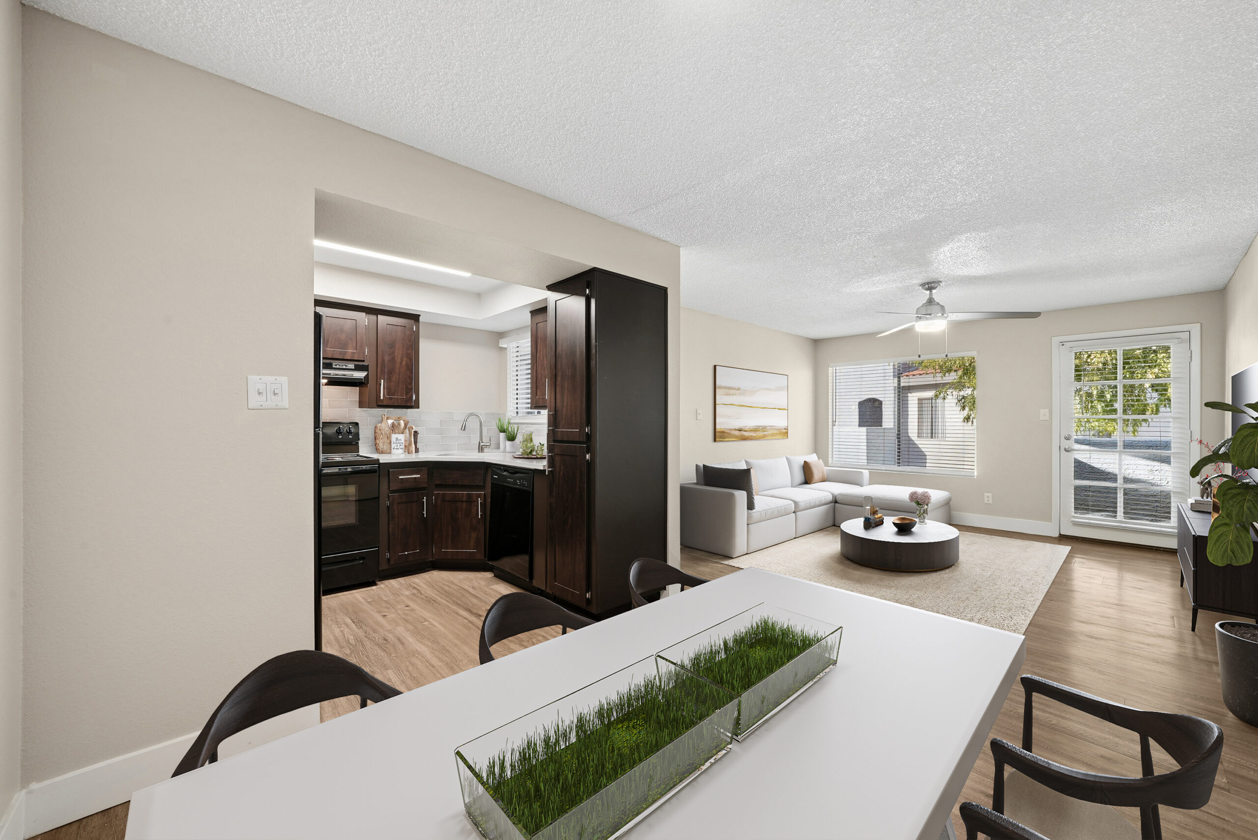Dining area at Arches at Hidden Creek with an open view of the classic kitchen and naturally lit living room.